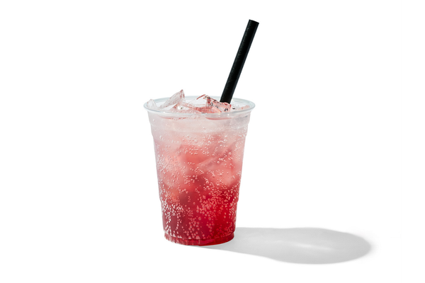 A clear plastic cup containing a pink soda with ice and a black straw, casting a shadow on a white background.
