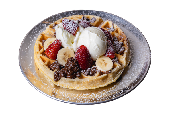A waffle topped with strawberries, bananas, whipped cream, chocolate, and powdered sugar on a plate.