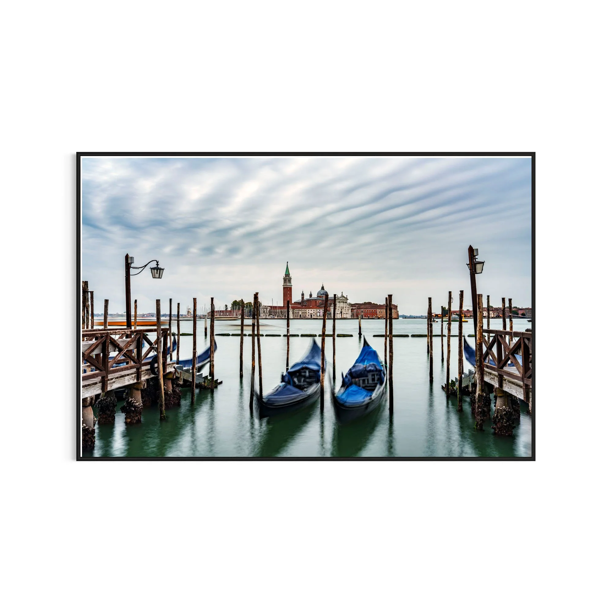 A serene long-exposure photograph of gondolas and Venice in stillness. Fine art photography exploring time, water and quiet anticipation.