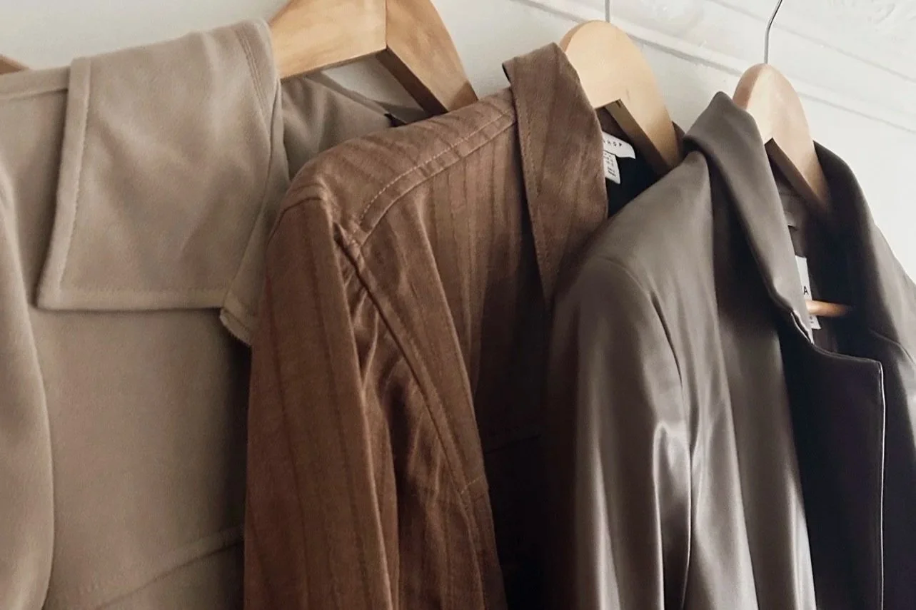 A photo of 3x brown jackets on hangers.