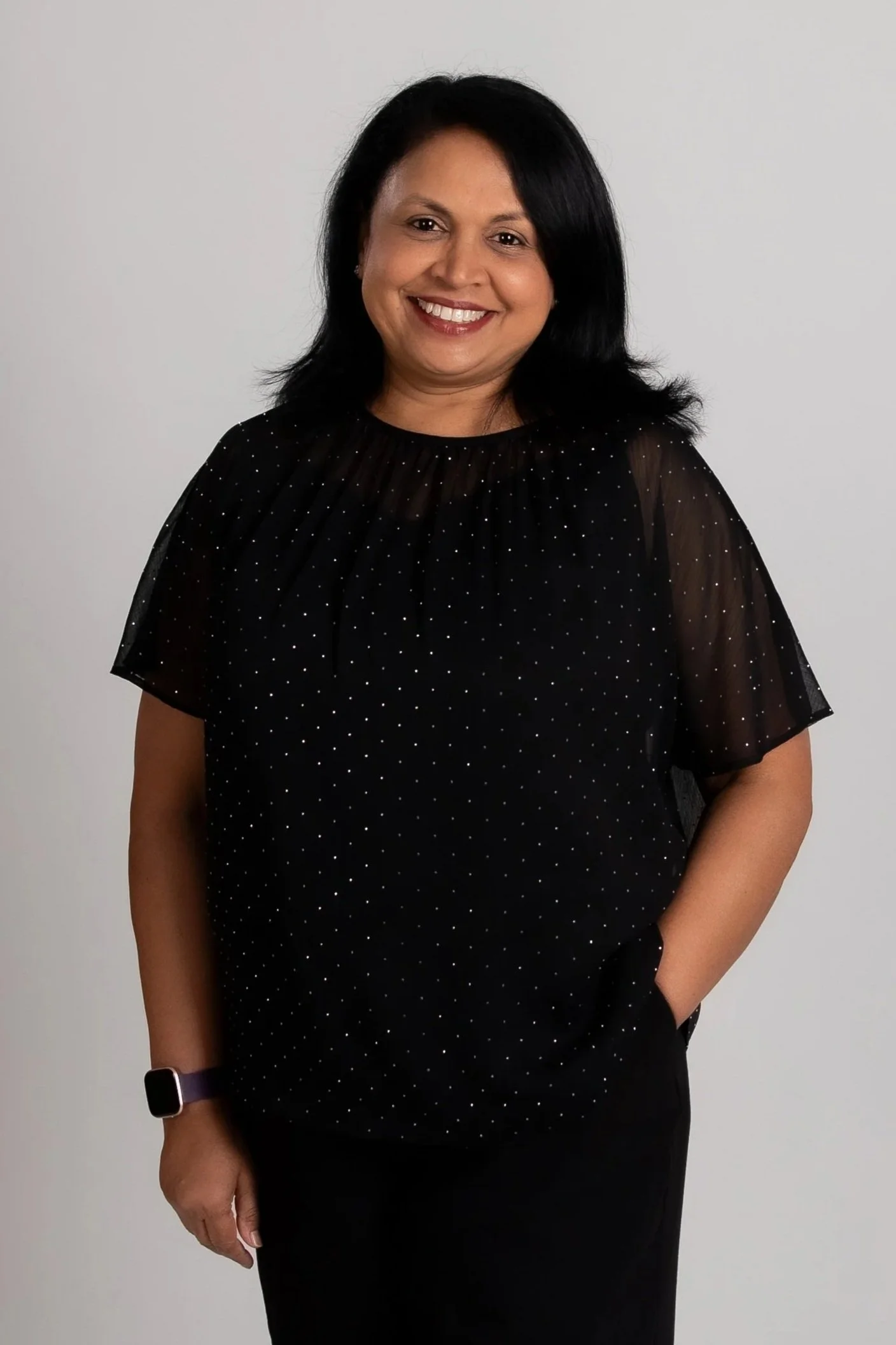 A close-up head shot of Judith Silva in front of stone background.