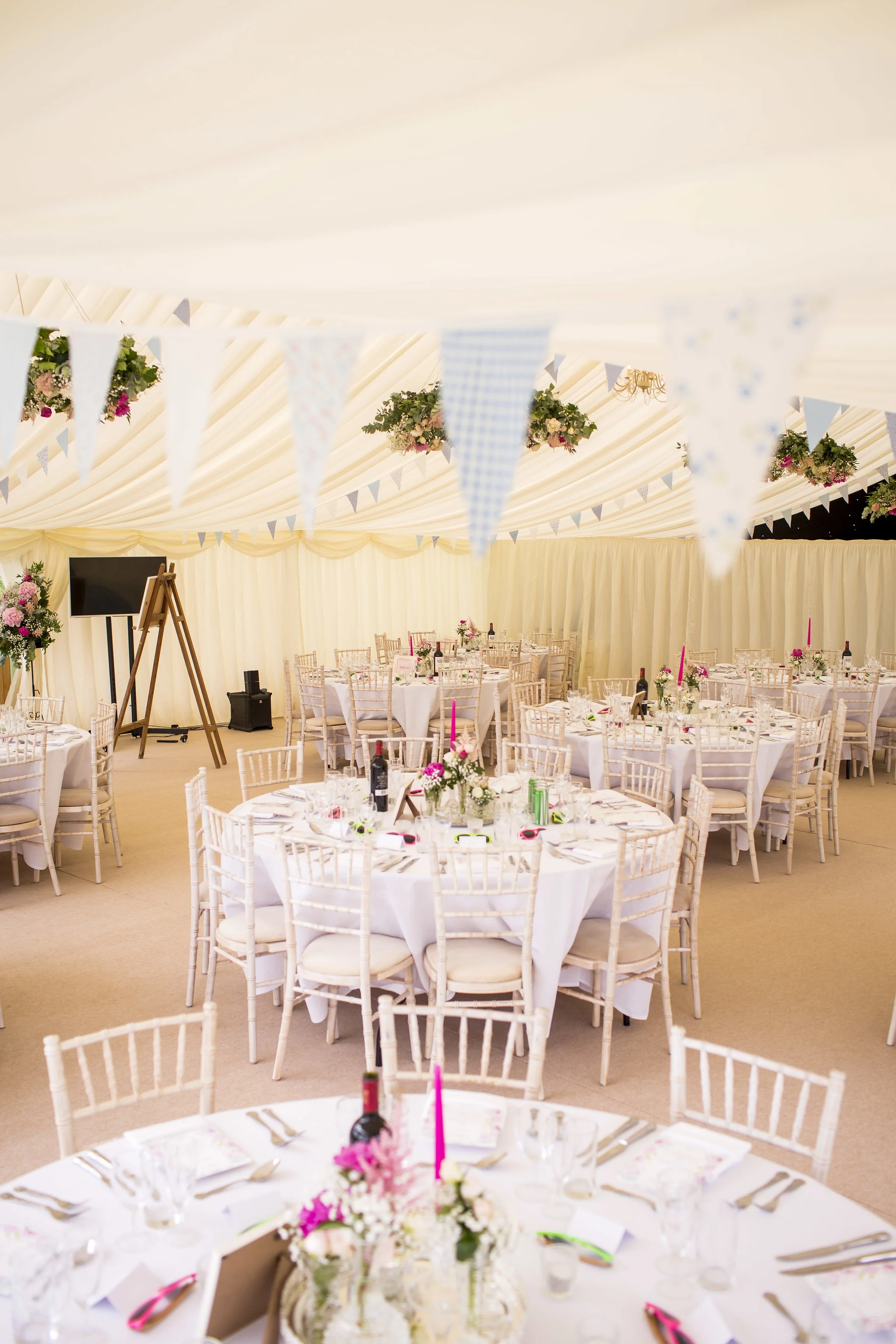 Internal wedding marquee reception In Herefordshire showing round tables with chivari chairs