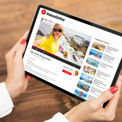 Person holding a tablet displaying a travel YouTube channel titled "My Travel Adventures" with a woman in a yellow top and sunglasses in a scenic outdoor setting.