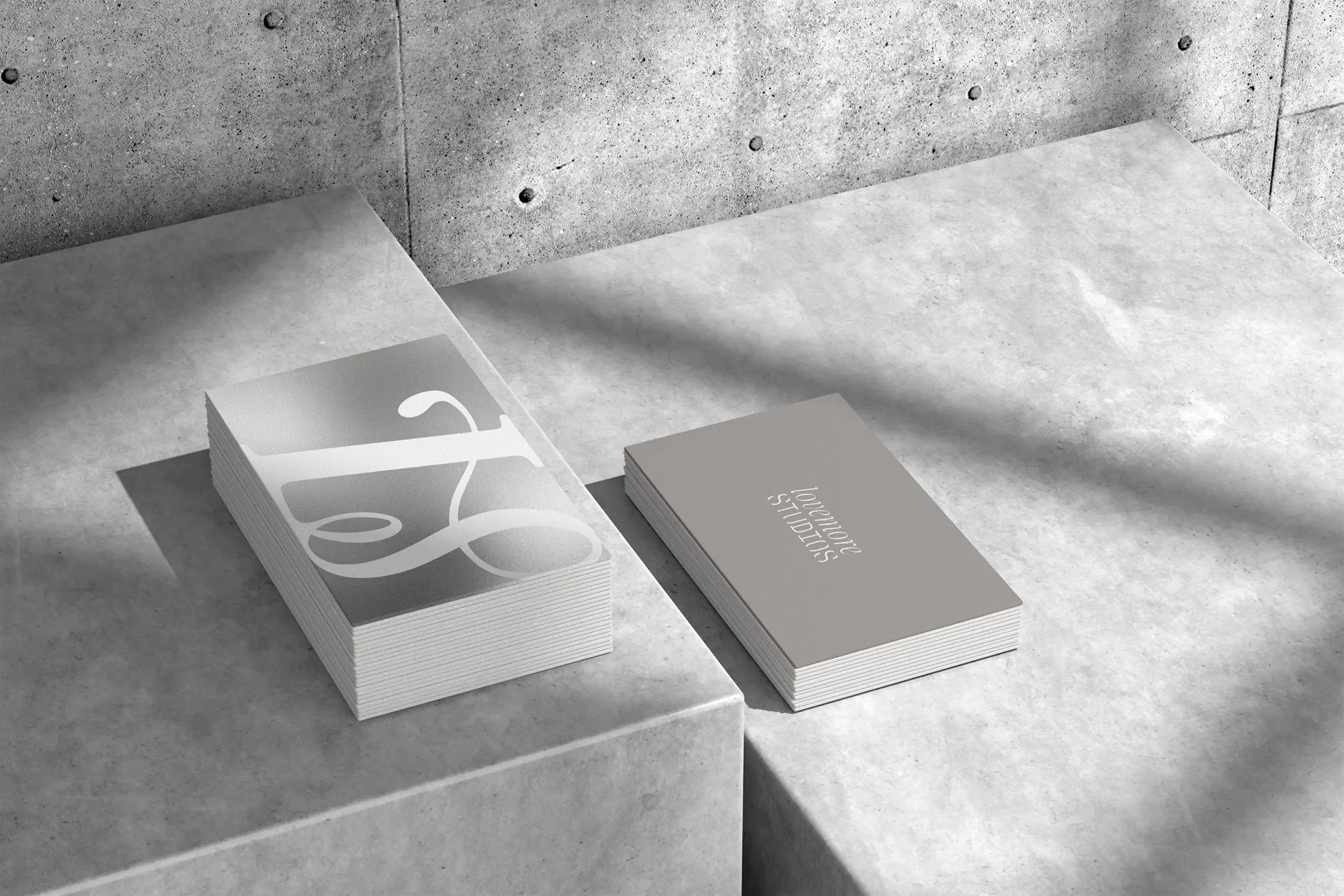 Stacks of business cards on a concrete surface with a concrete wall in the background.