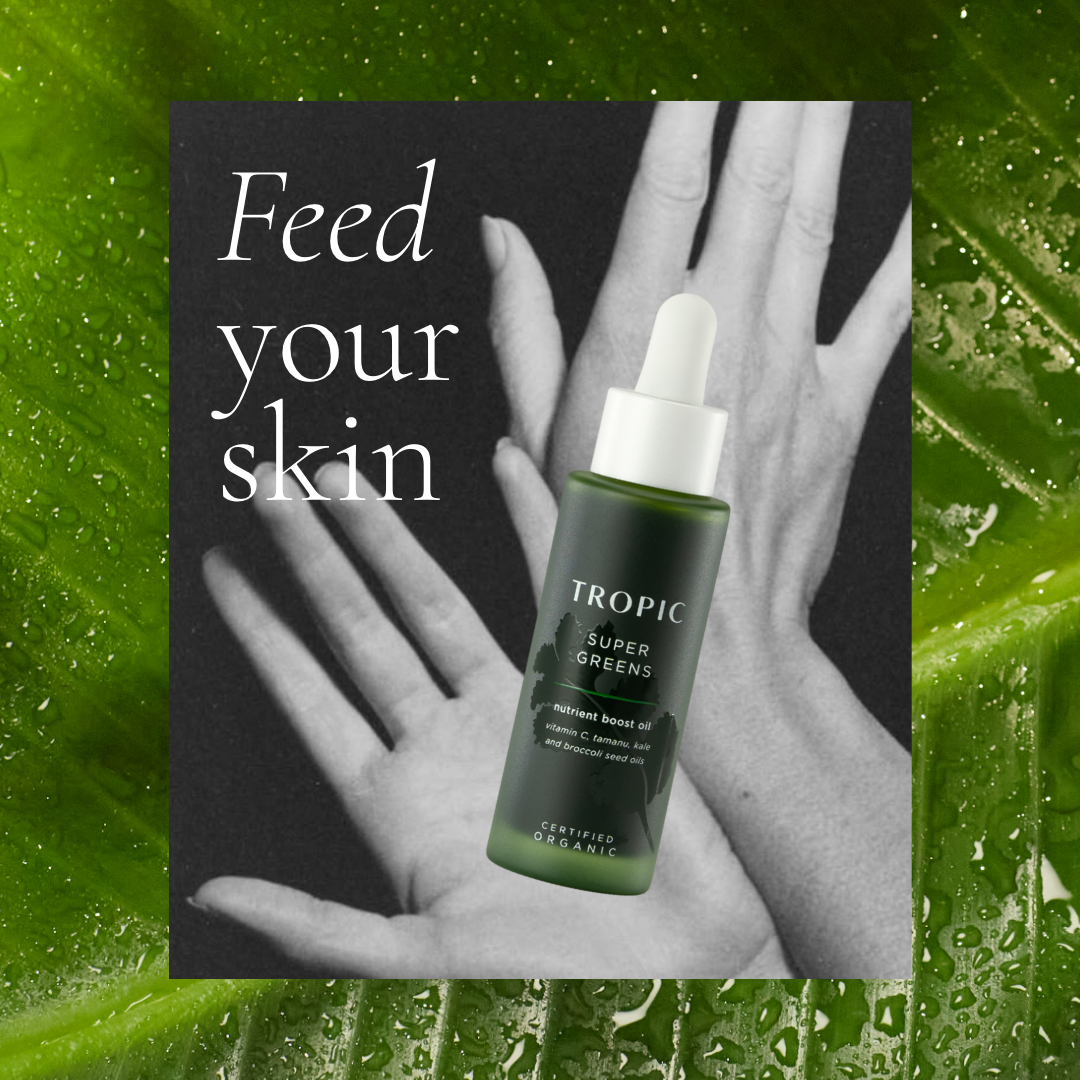A skincare product called Tropic Super Greens nutrient boost oil with vitamin C, tamanu, kale, and broccoli seed oils, superimposed over a black and white image of hands on a green leafy background with water droplets, and the text 'Feed your skin'.