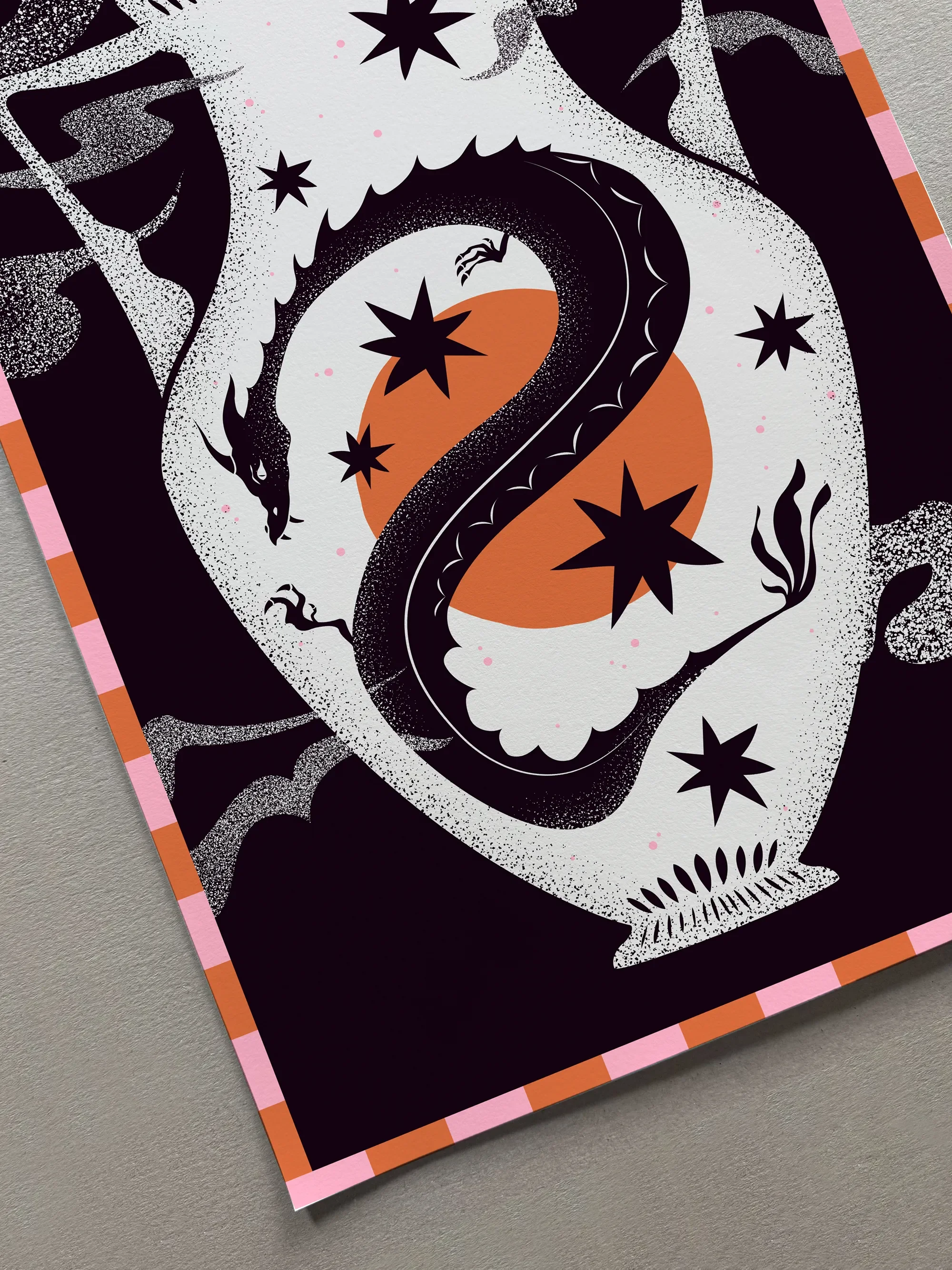 A colorful illustration of a black snake coiled around a pumpkin against a backdrop of stars and abstract shapes, with a decorative orange and pink checkered border.