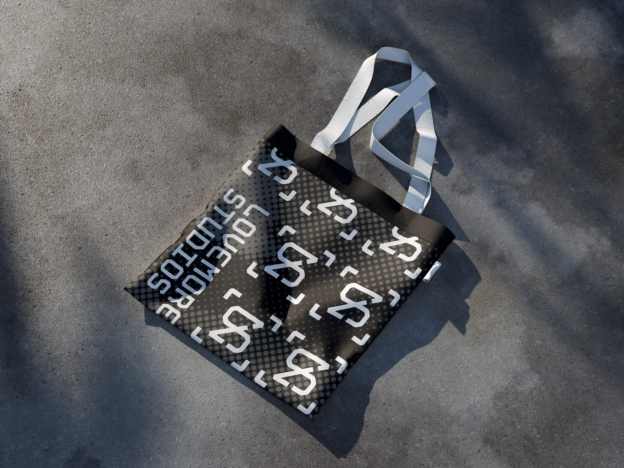 A shopping bag with a black and white design featuring the word 'YES' repeatedly printed in bold, capital letters, sits on a concrete ground with a long white strap extending from it.