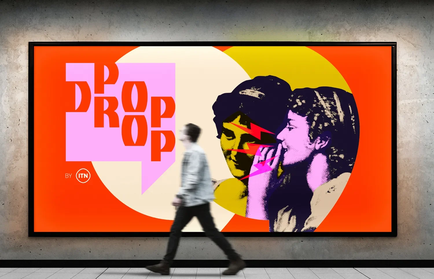 Colorful advertisement featuring two women in pop art style with lightning bolt graphics, large pink speech bubble with red text 'POP POP POP', and a small ITN logo in the bottom left corner. A person walks past in front of the poster.