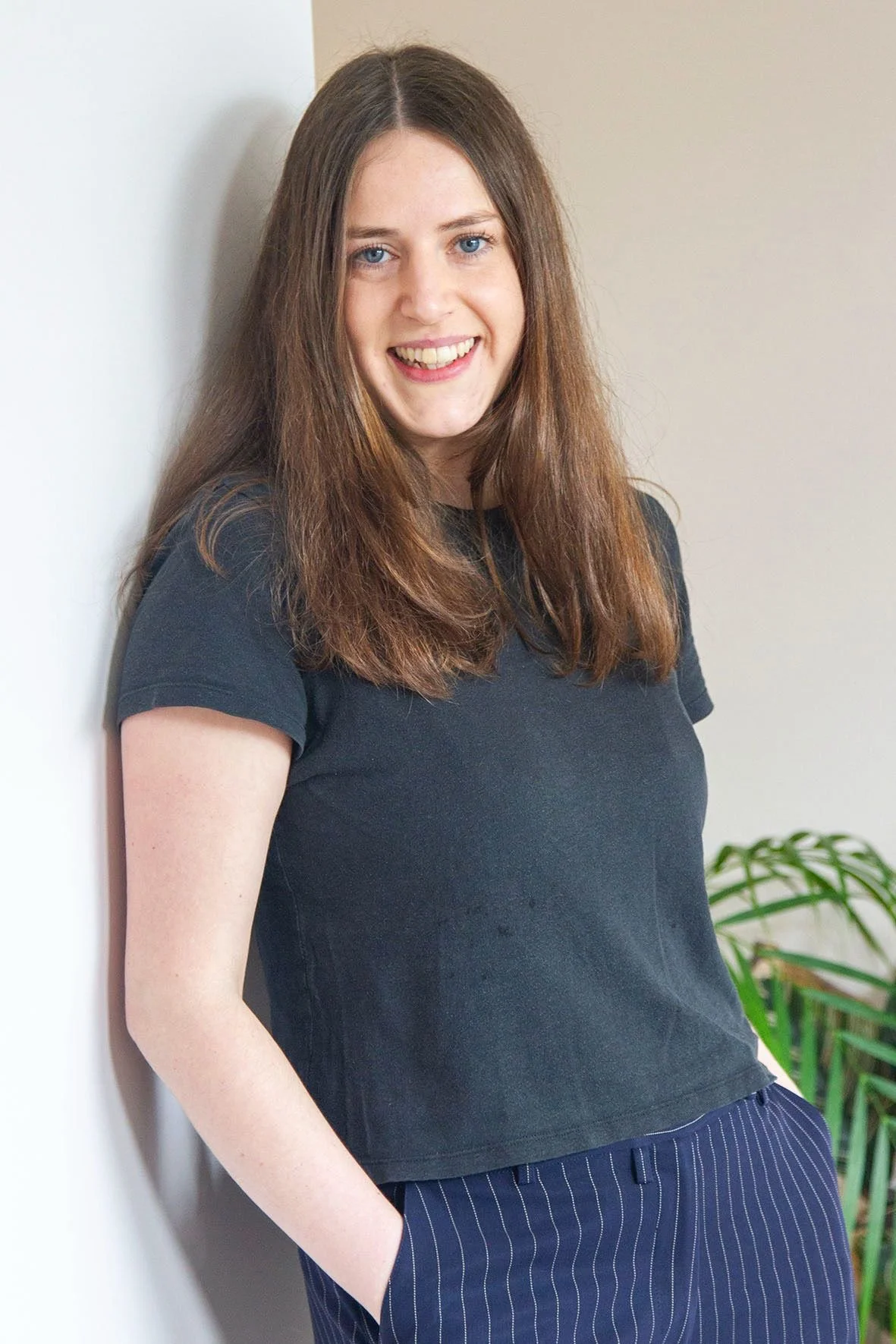 lady standing smiling by a wall