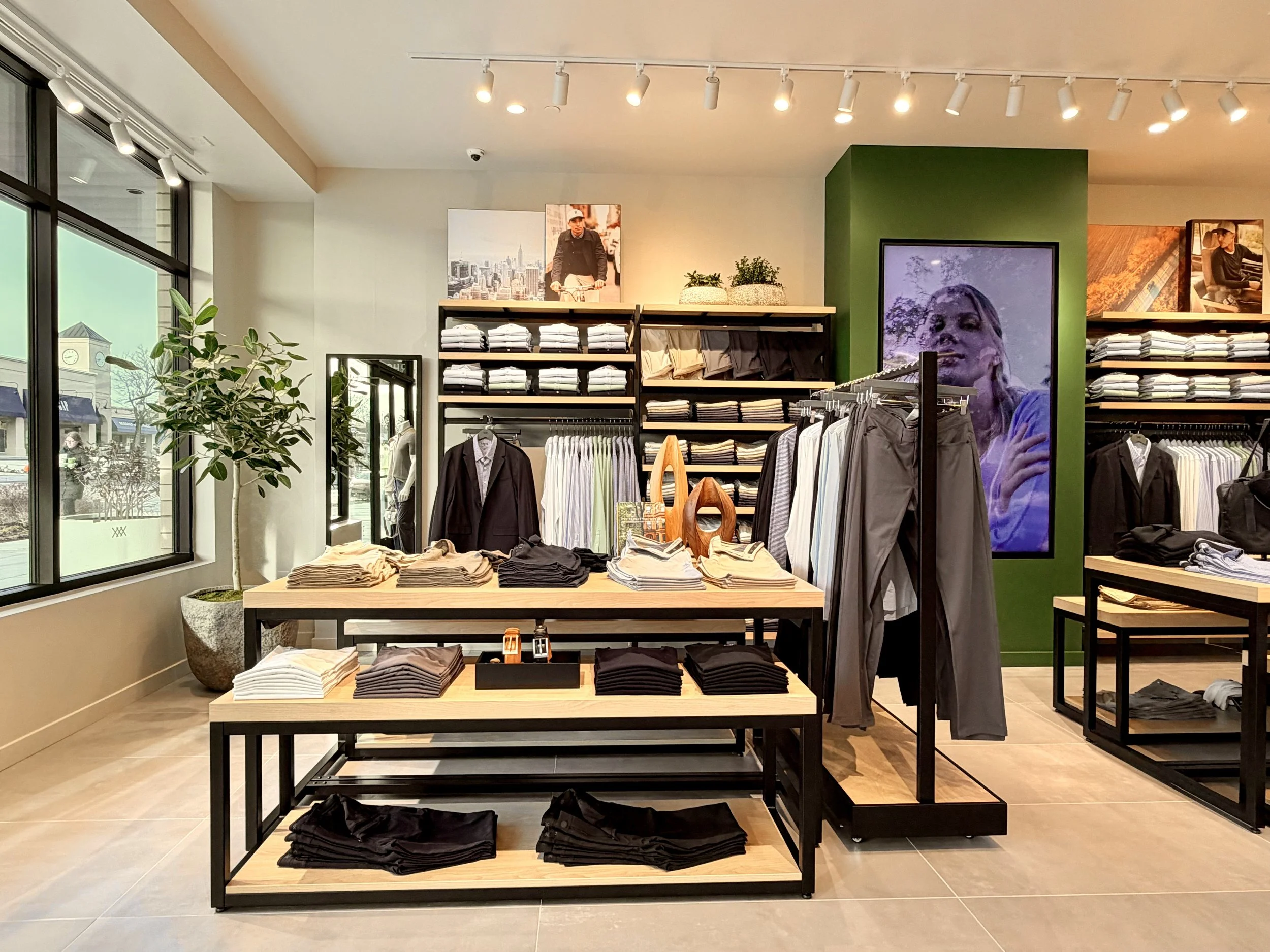 Photo of a retail clothing store display with shirts and pants.