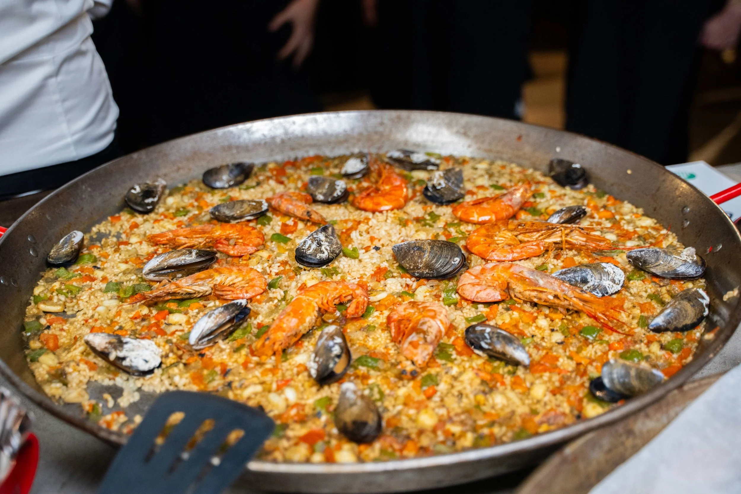 A large pan of seafood paella with shrimp, mussels, and rice.