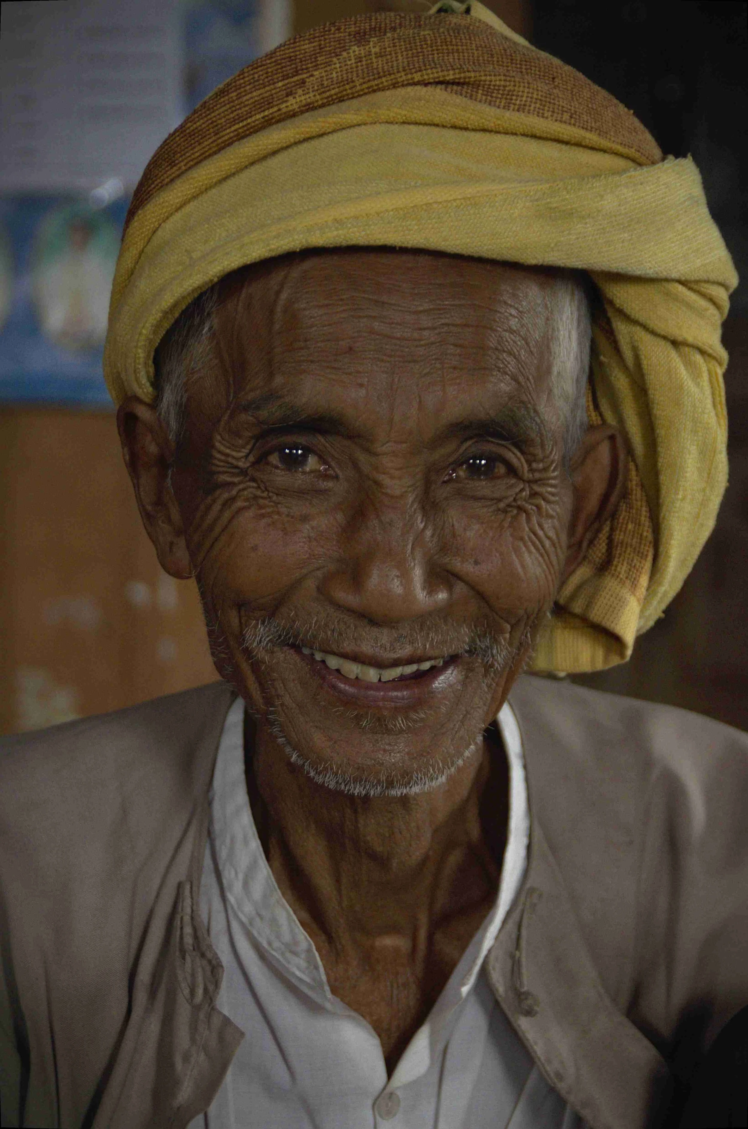 Un homme âgé souriant portant un turban jaune