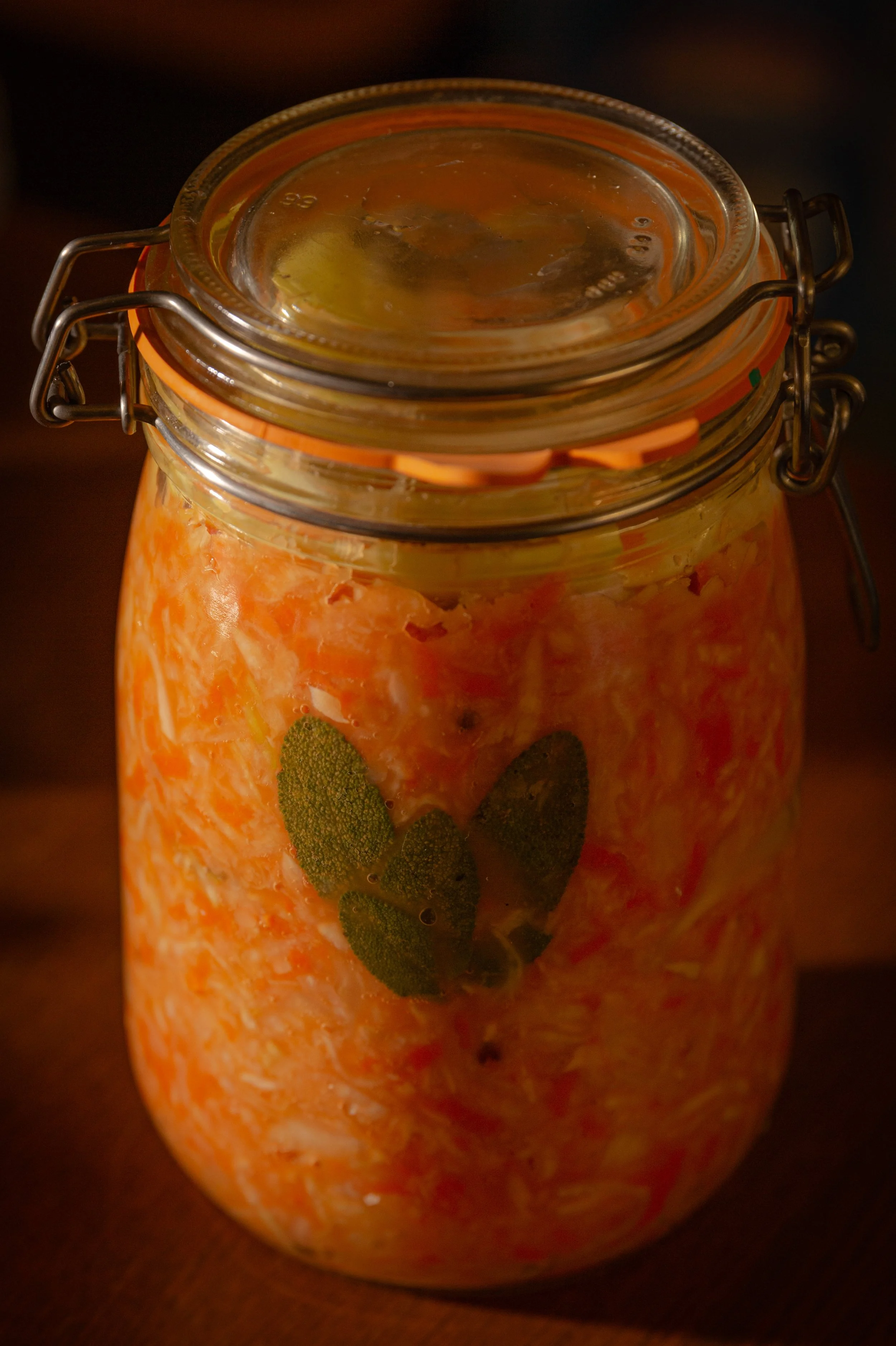 Pot de conserve contenant un mélange de fruits émincés et des feuilles de menthe