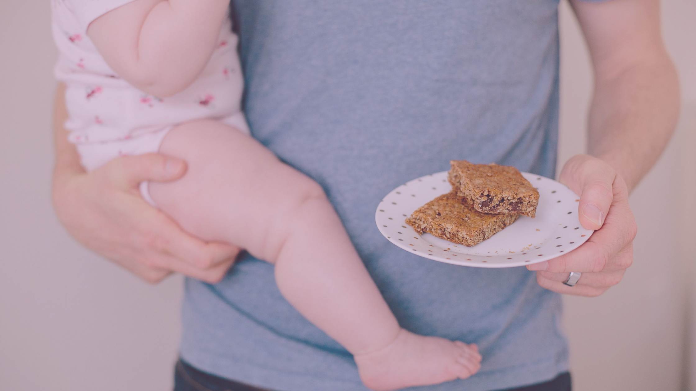 Dad holding baby and plate with lactation cookies