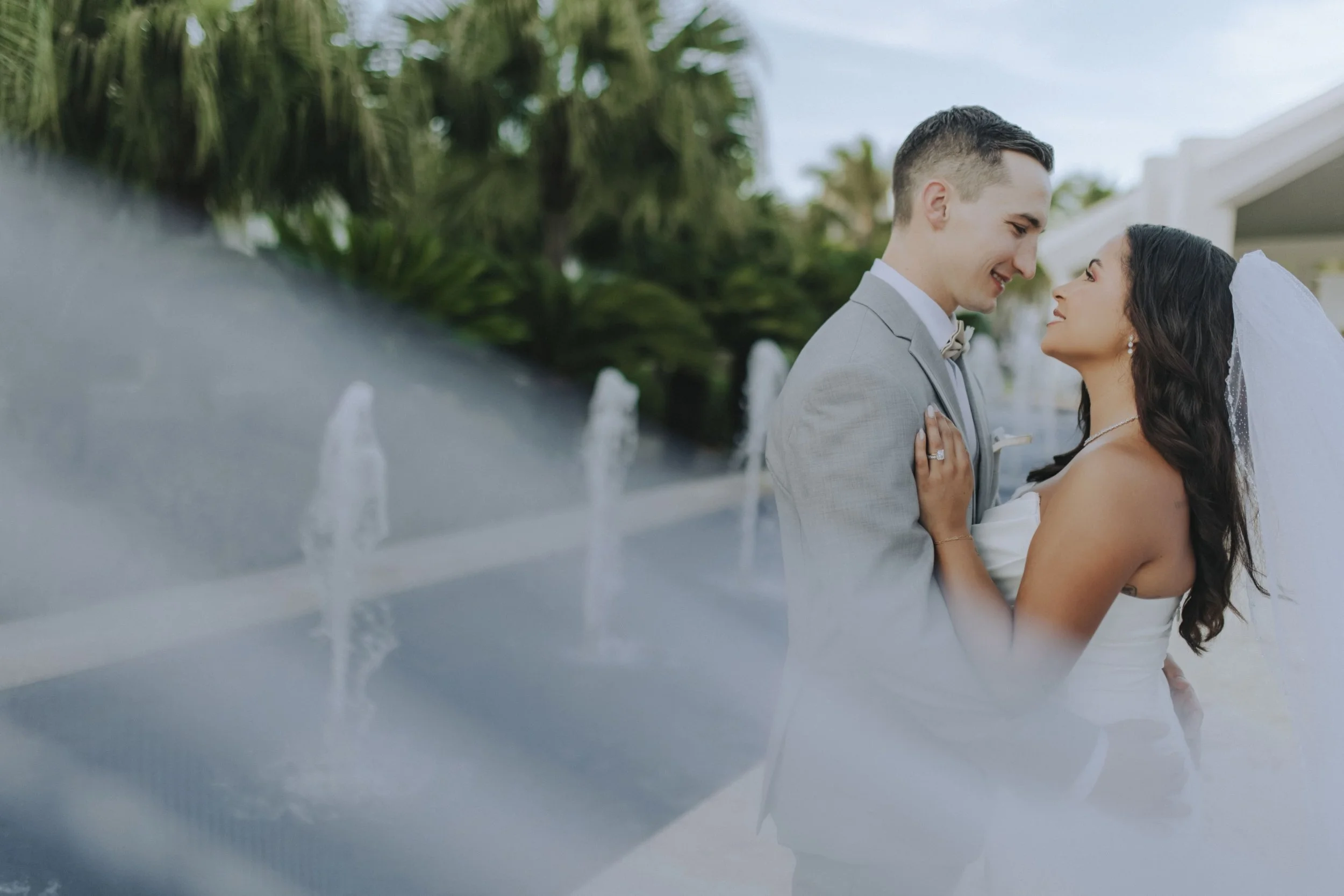 Bride and groom in a close embrace, foreheads nearly touching, during portraits at Dreams Onyx