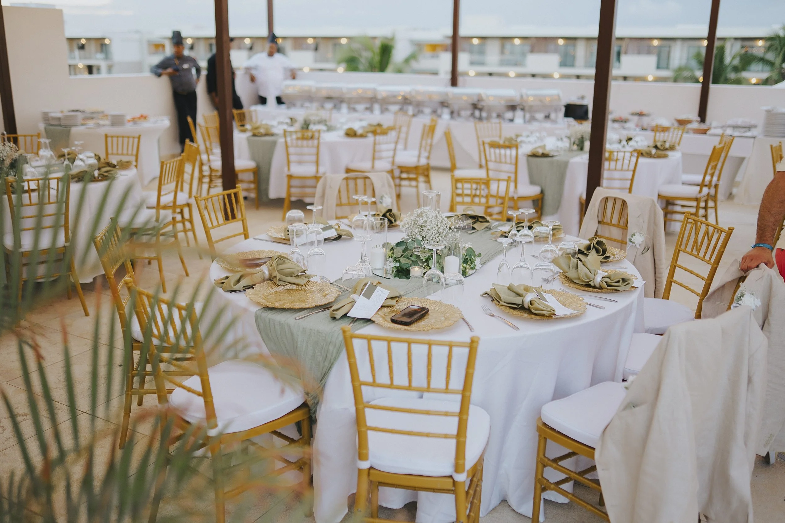 Gold and sage table settings ready for the rooftop reception at Serenade Punta Cana
