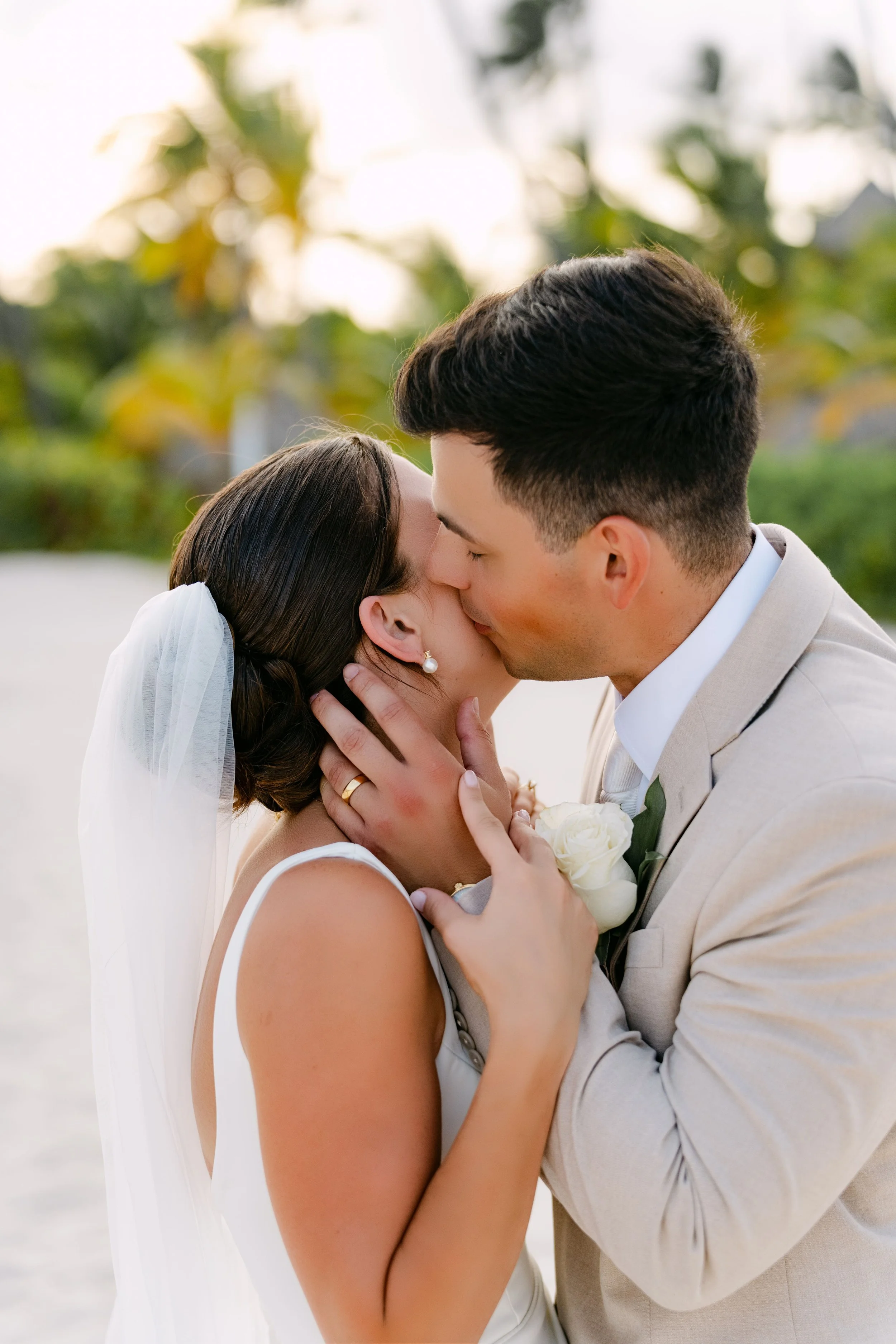 Groom kissing bride's forehead, veil flowing, Dreams Royal Beach Punta Cana wedding by WBA Studio.