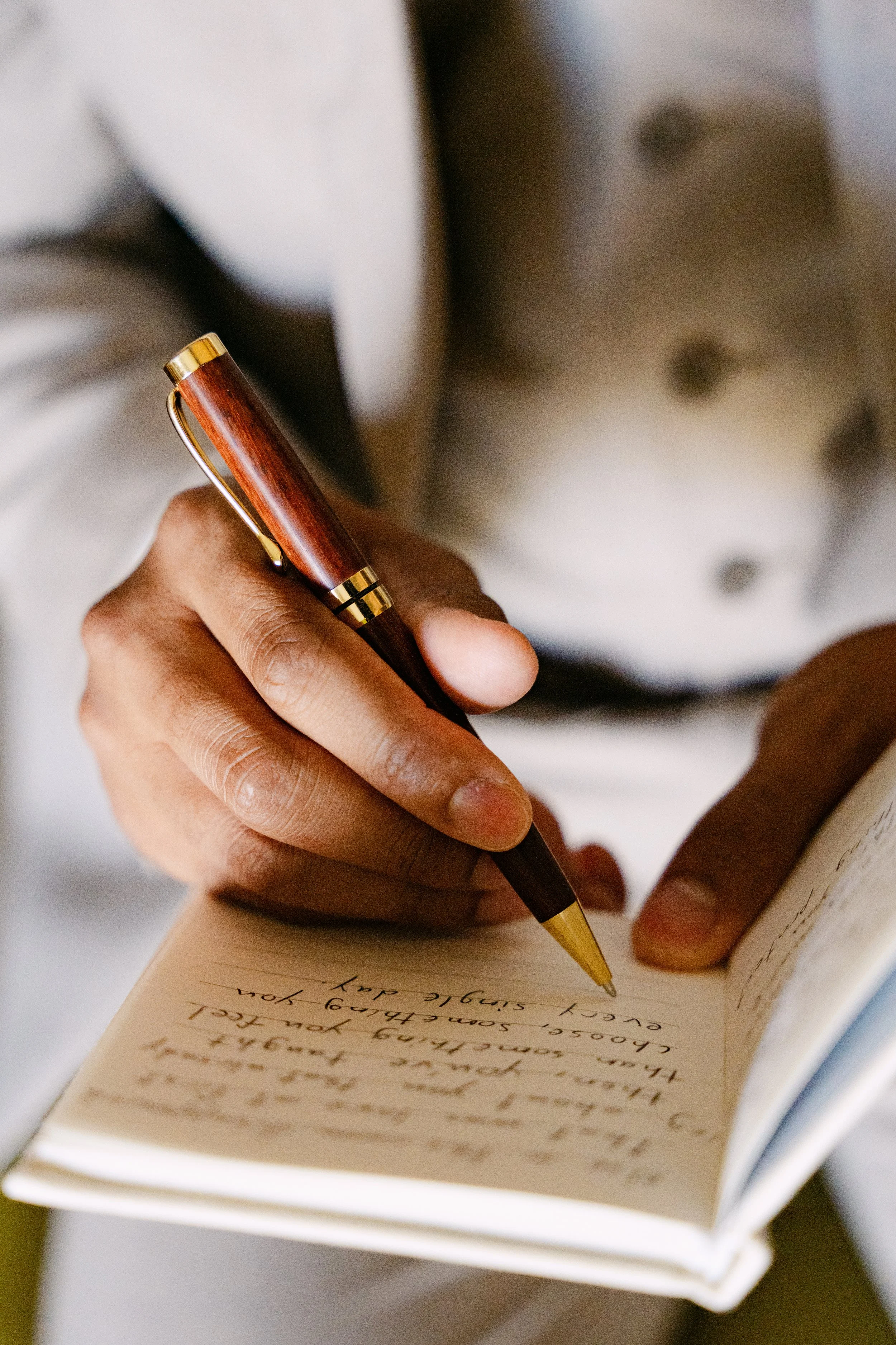Hand holding a pen writing a handwritten letter on wedding morning at Dreams Onyx Punta Cana