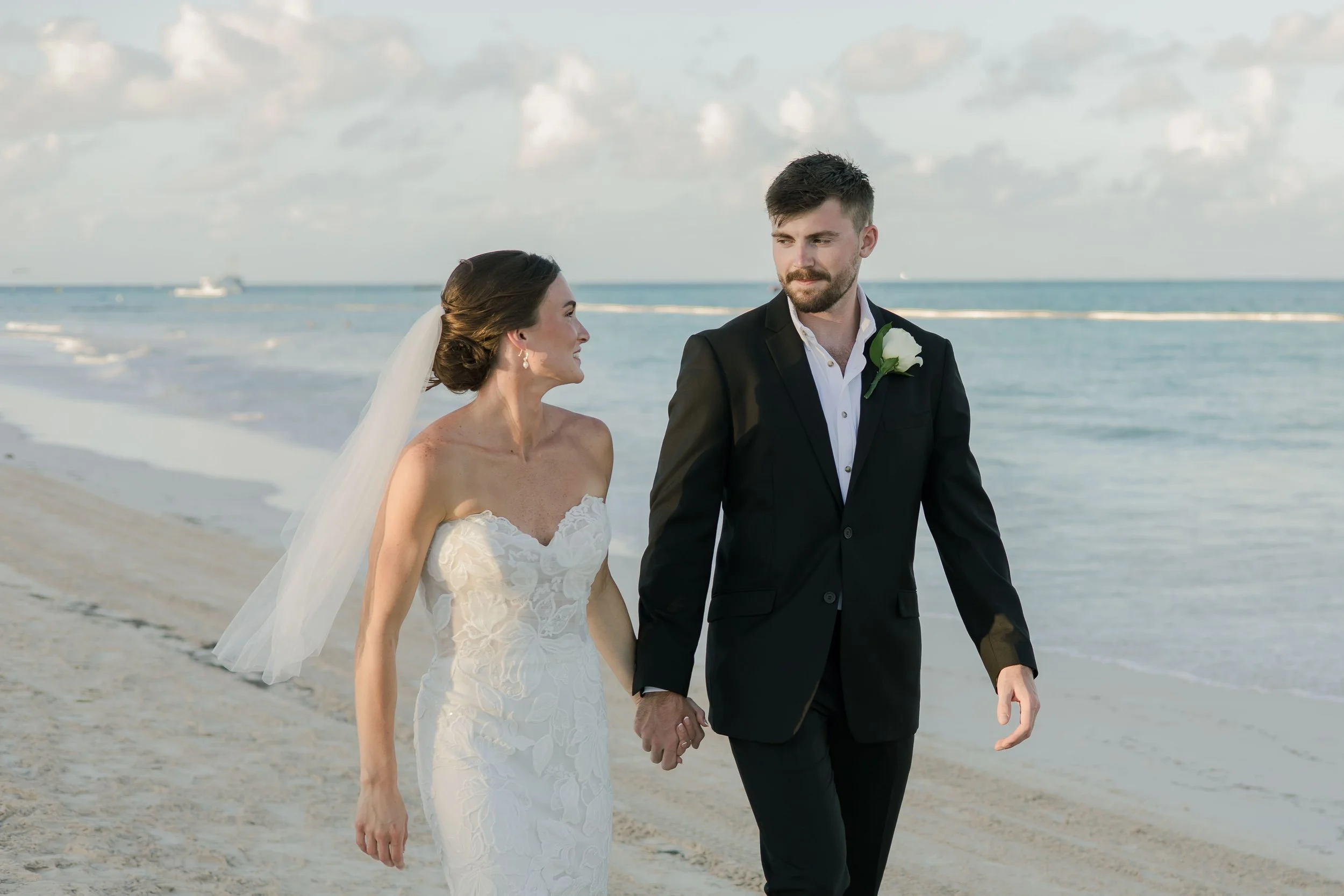 Bride and groom walking hand in hand along the beach, Punta Cana destination wedding by WBA Studio.