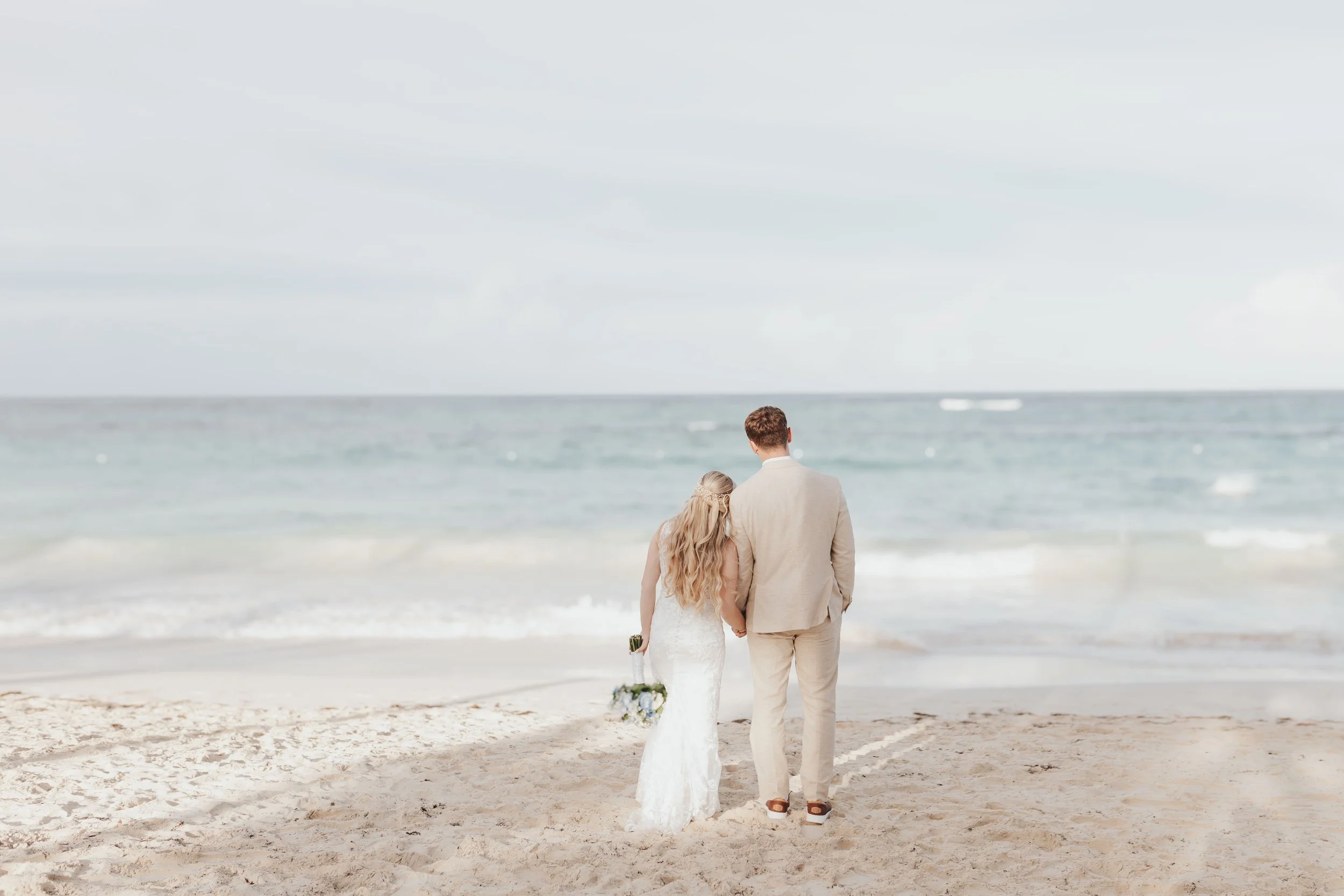 Bride and groom walking along the beach at Riu Punta Cana wedding
