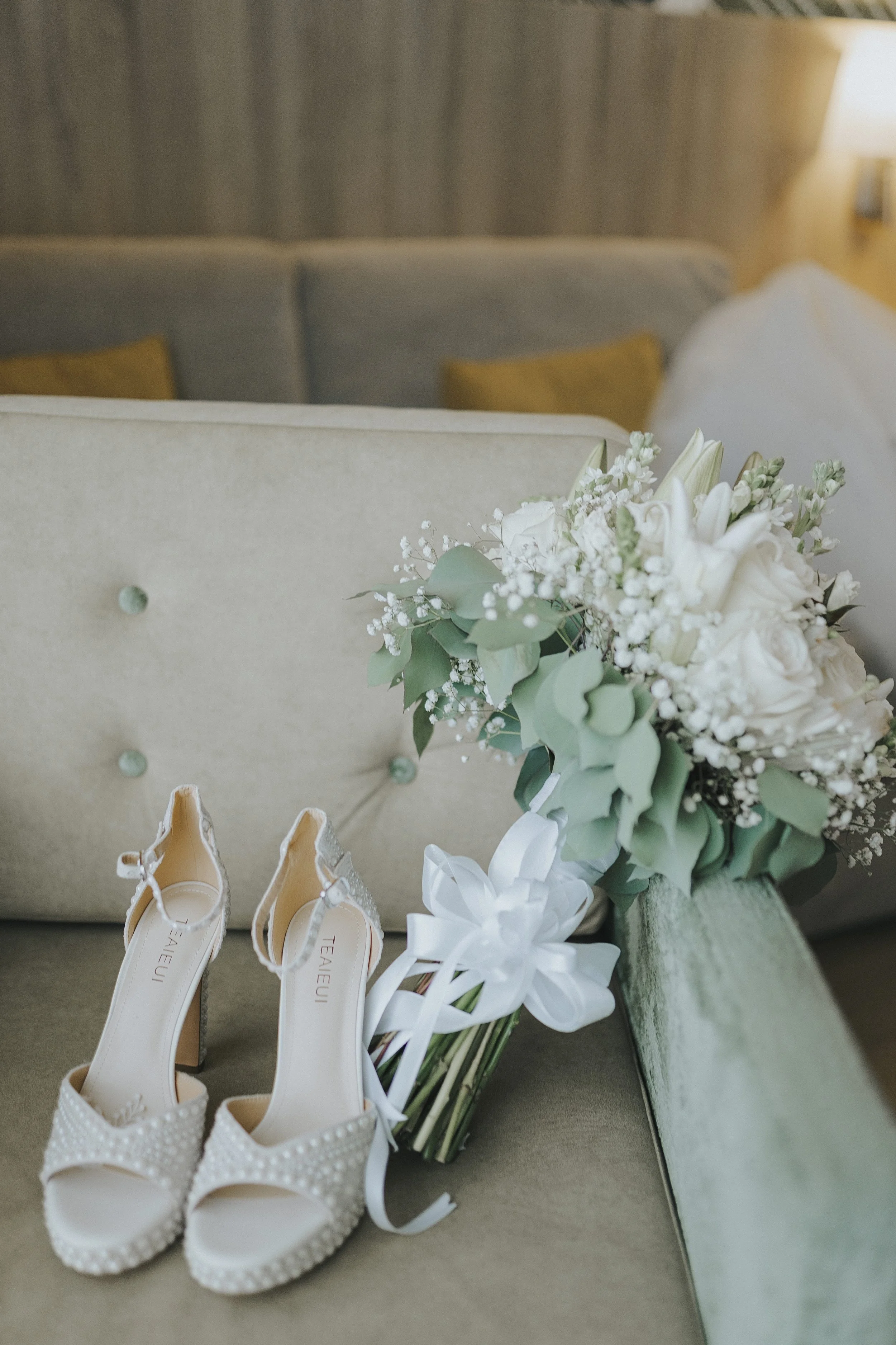 Bride's pearl-detailed heels and bridal bouquet styled together before getting dressed
