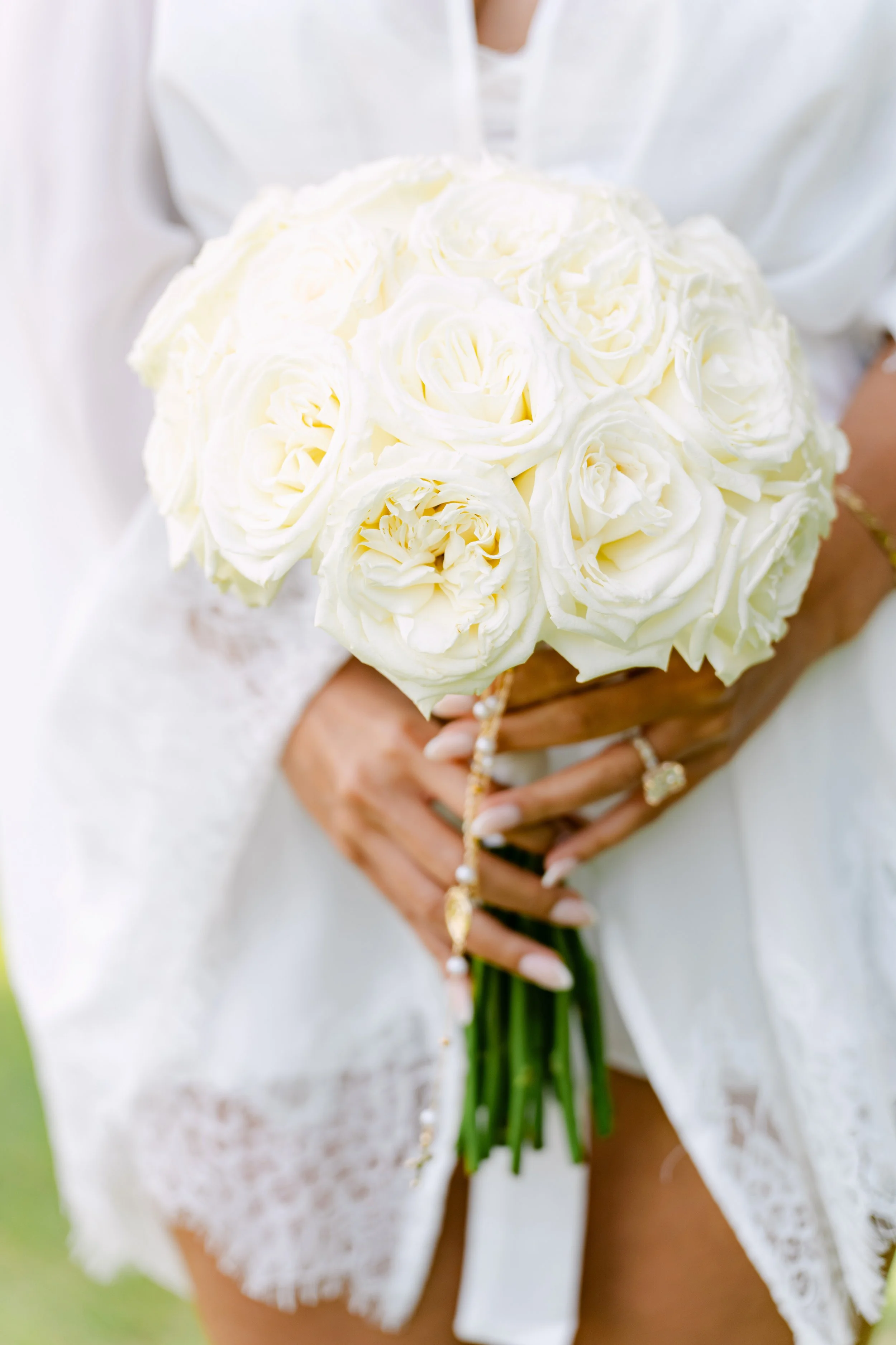 Bride holding a white rose bouquet in a white wedding gown