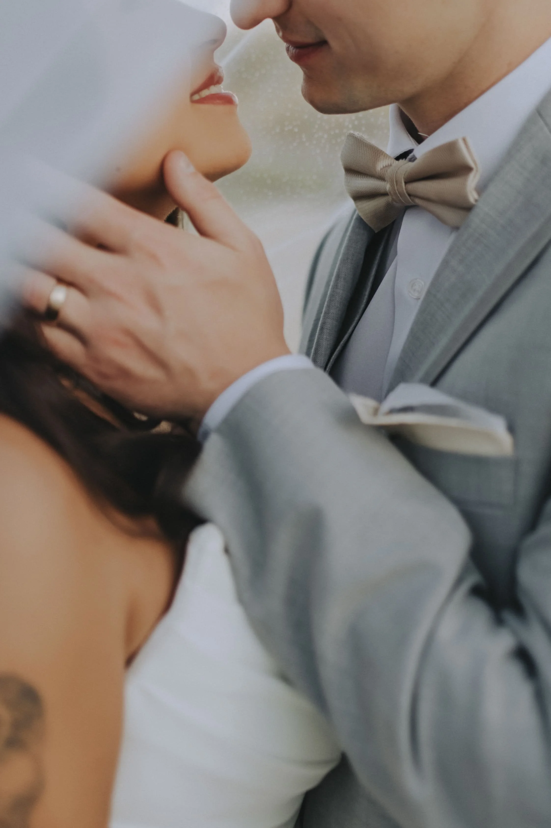Close-up of groom's hand and engagement ring resting on groom's shoulder during a portrait embrace at Dreams Onyx