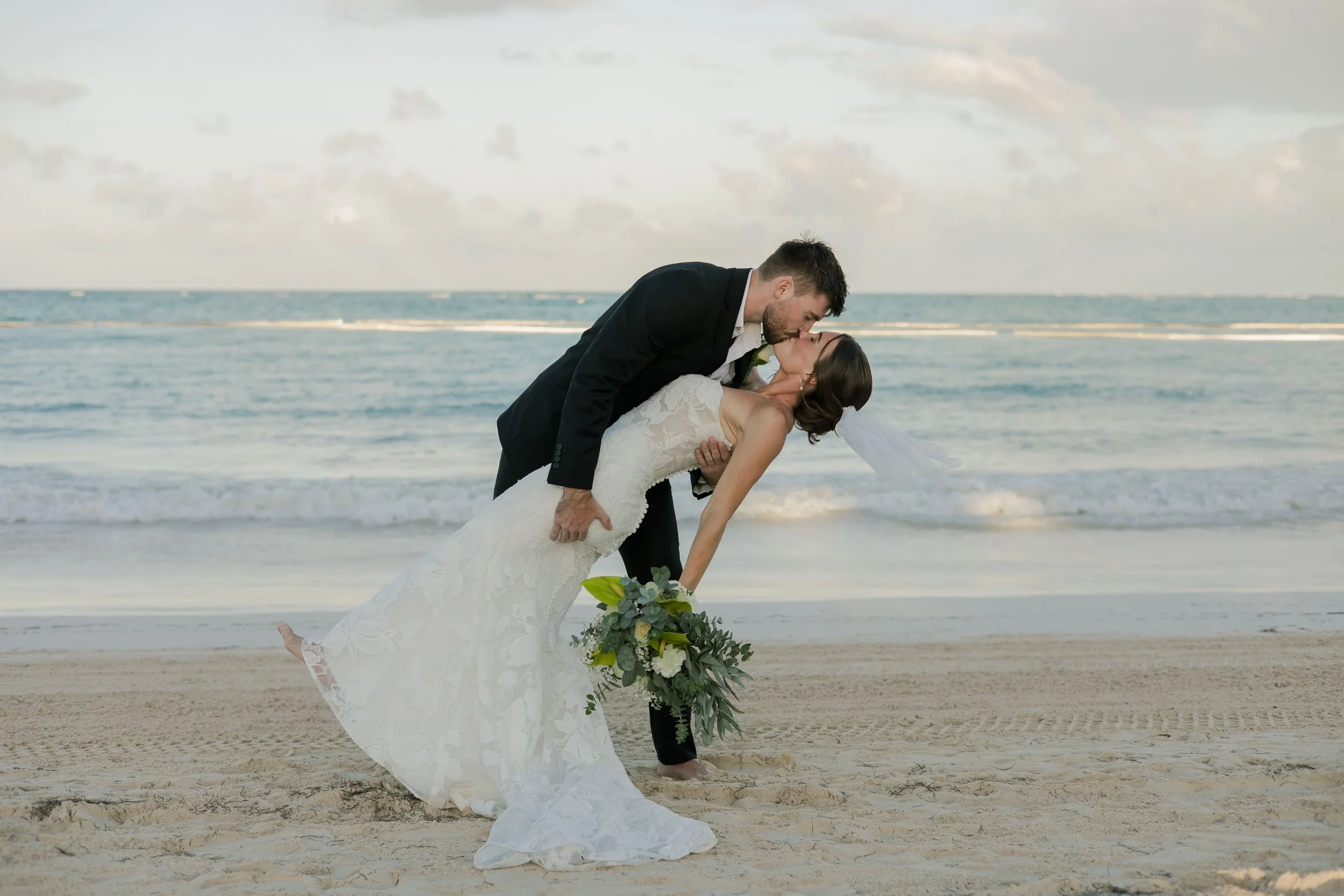 Groom dipping bride for a kiss on the beach, Punta Cana wedding photography by WBA Studio.