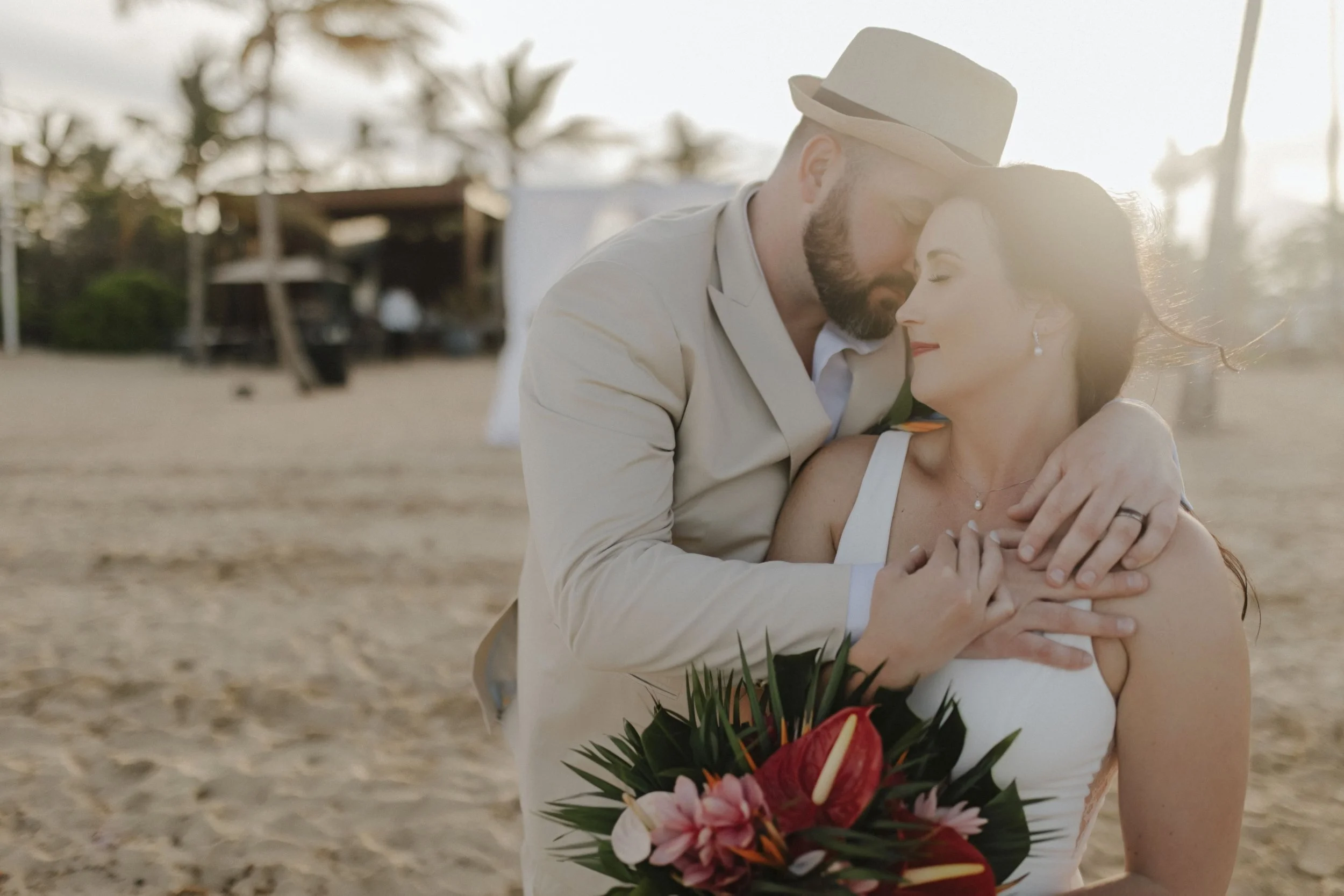 Bride and groom sharing a forehead kiss on the beach during golden hour portraits at Secrets Tides