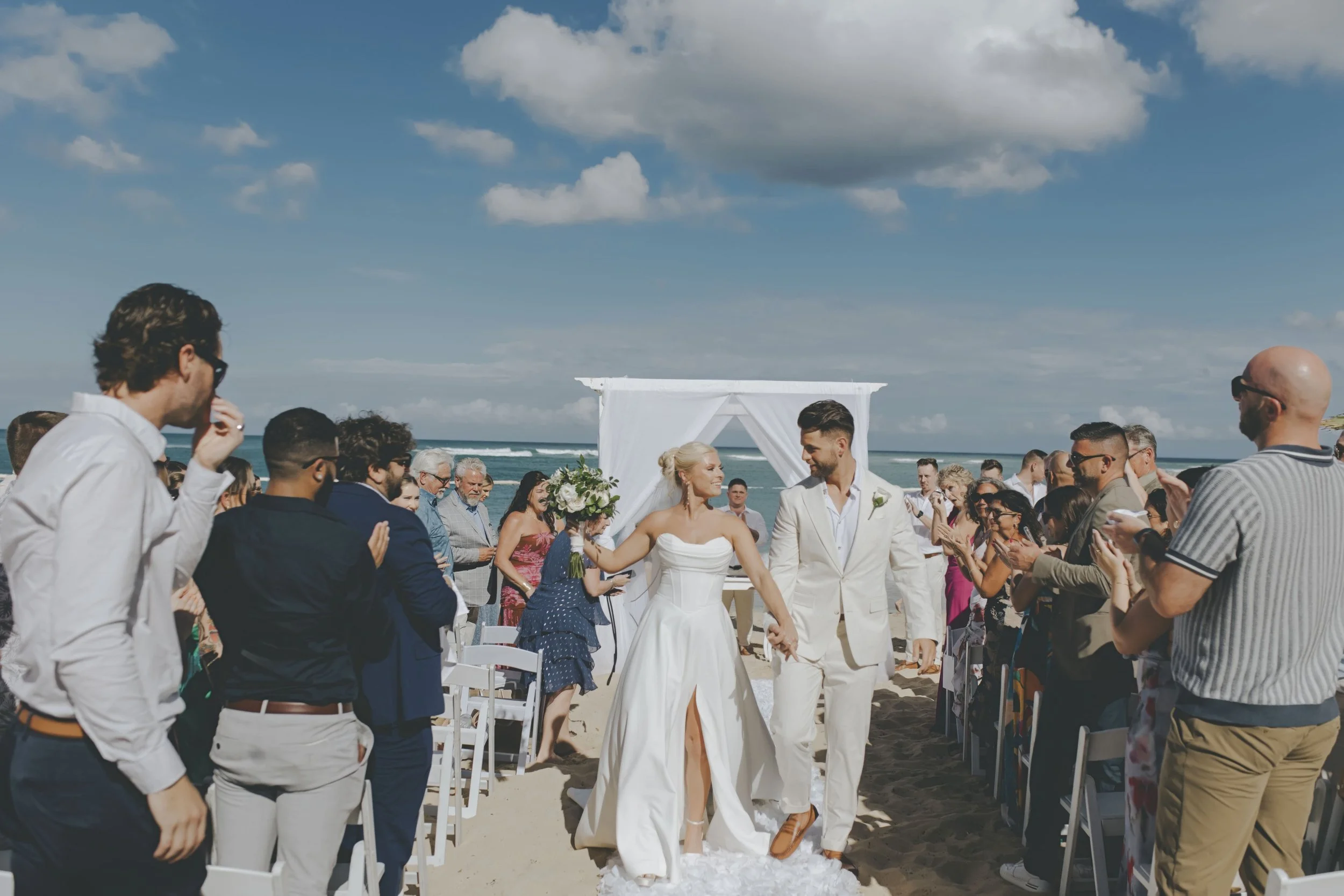 Bride and groom walking back down the aisle after their beach ceremony in Punta Cana