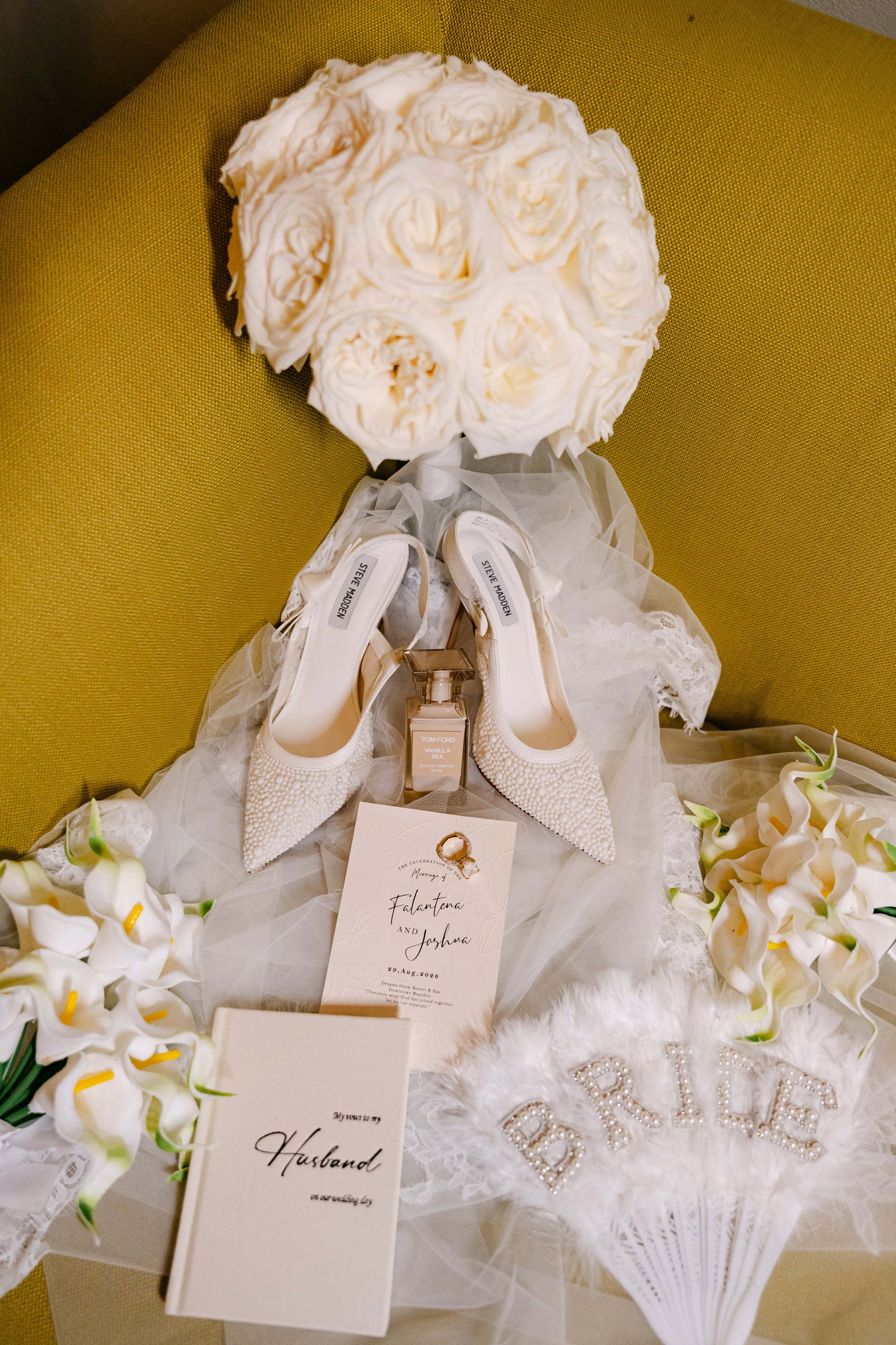 Flat lay of white bridal heels, a perfume bottle and white flowers styled for wedding detail photos