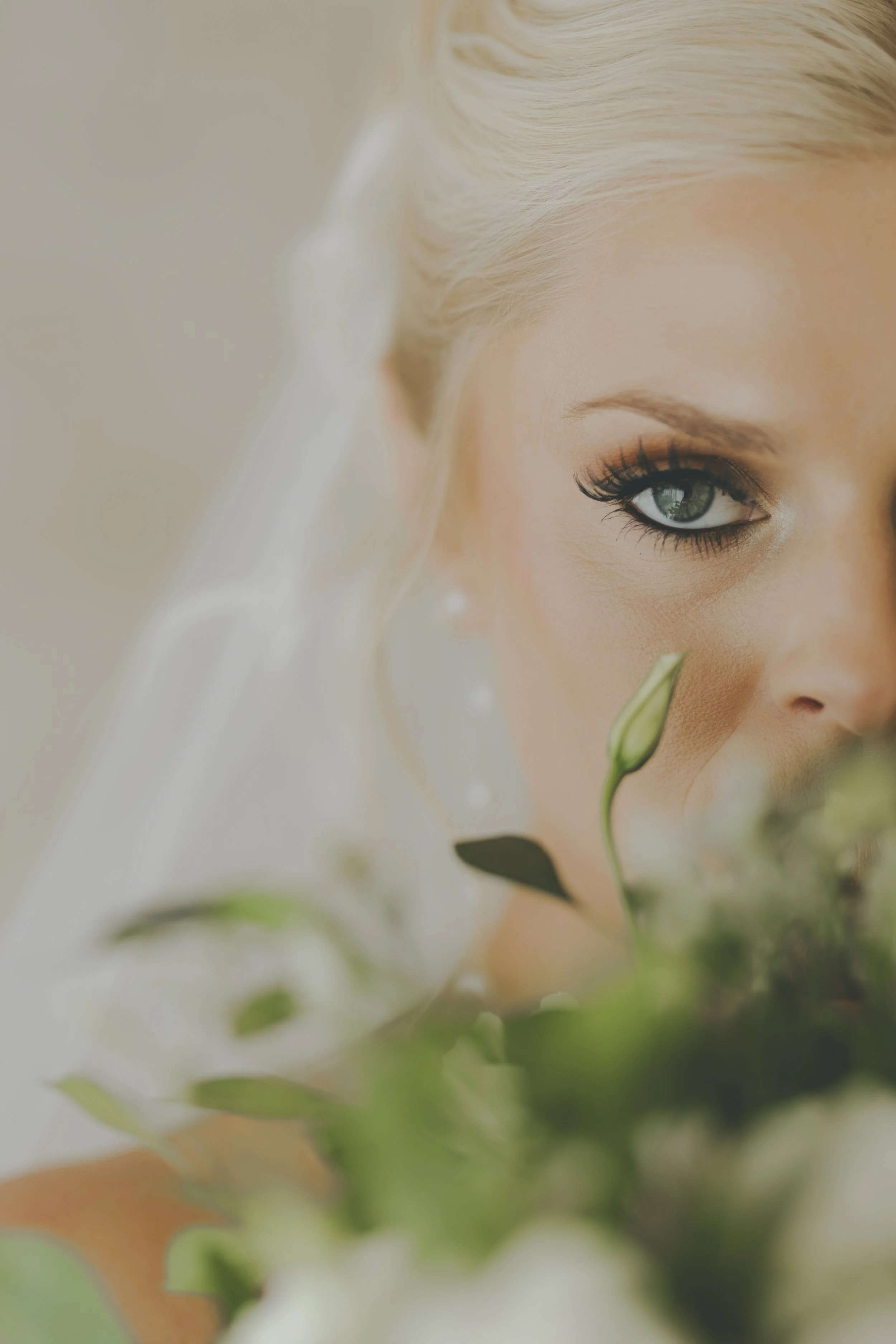 Bride peeking over her white rose bouquet before her destination wedding in Punta Cana