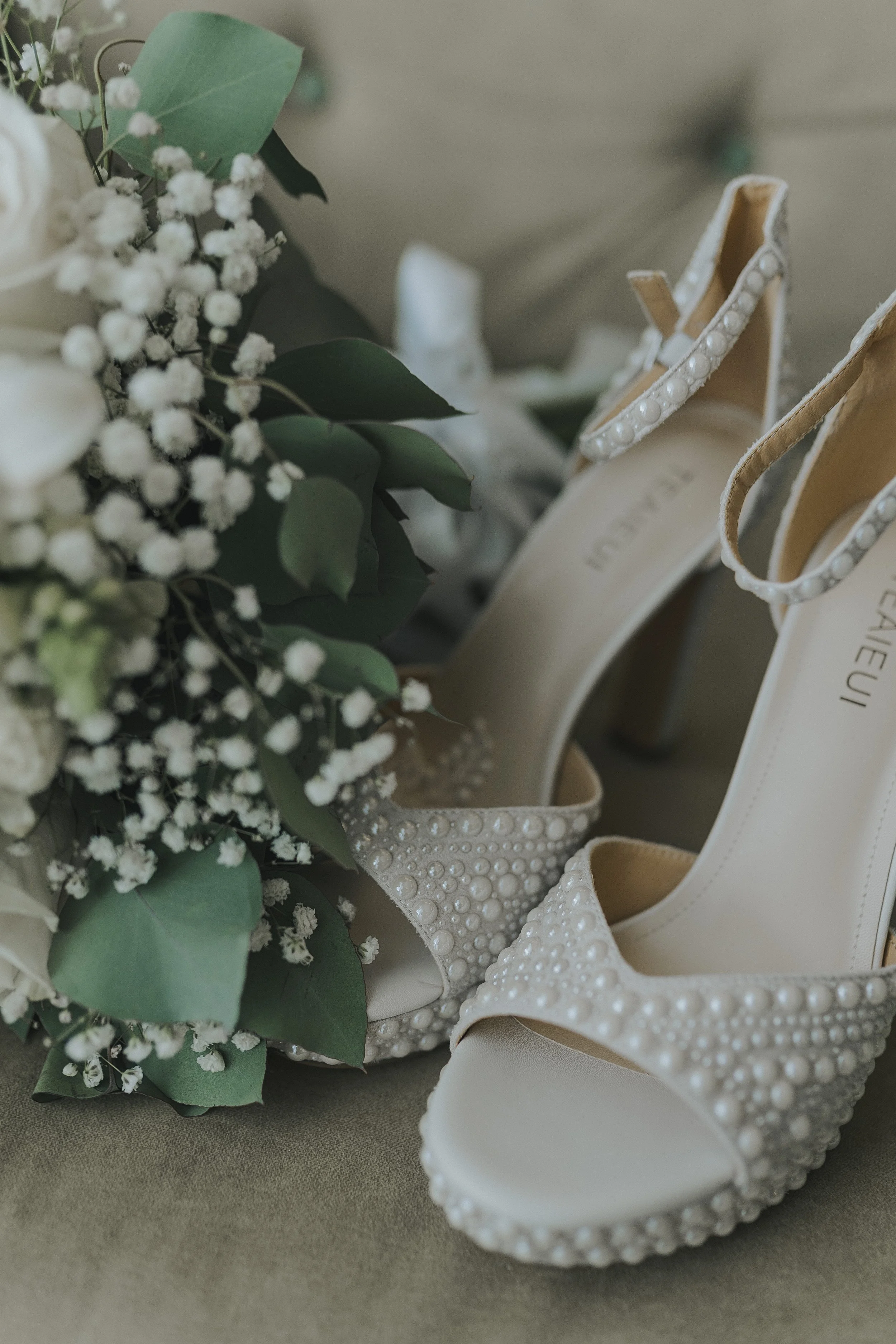 A closer look at the bride's white and green bouquet paired with her wedding day heels