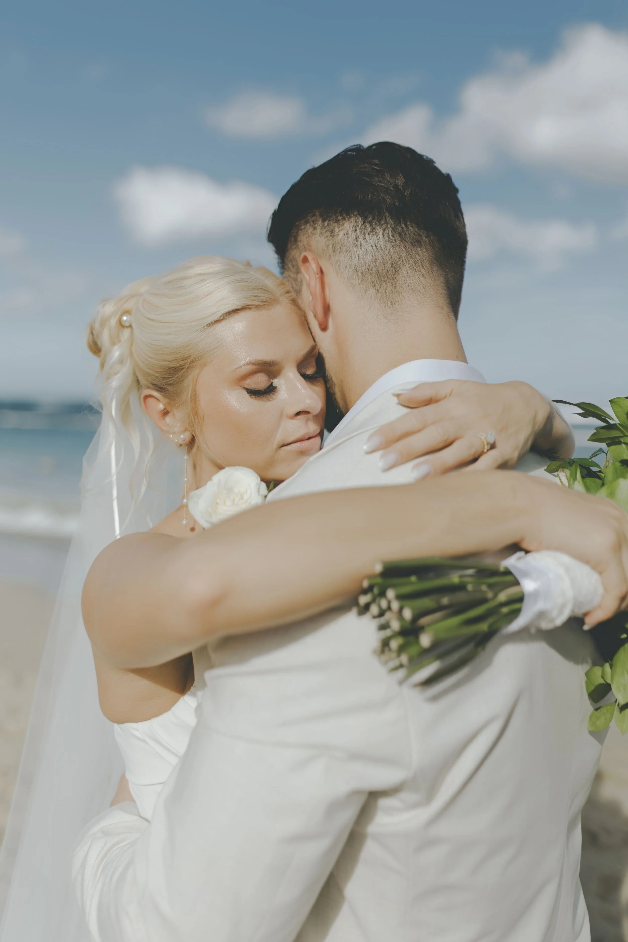 Bride and groom embracing during their beach portraits in Punta Cana