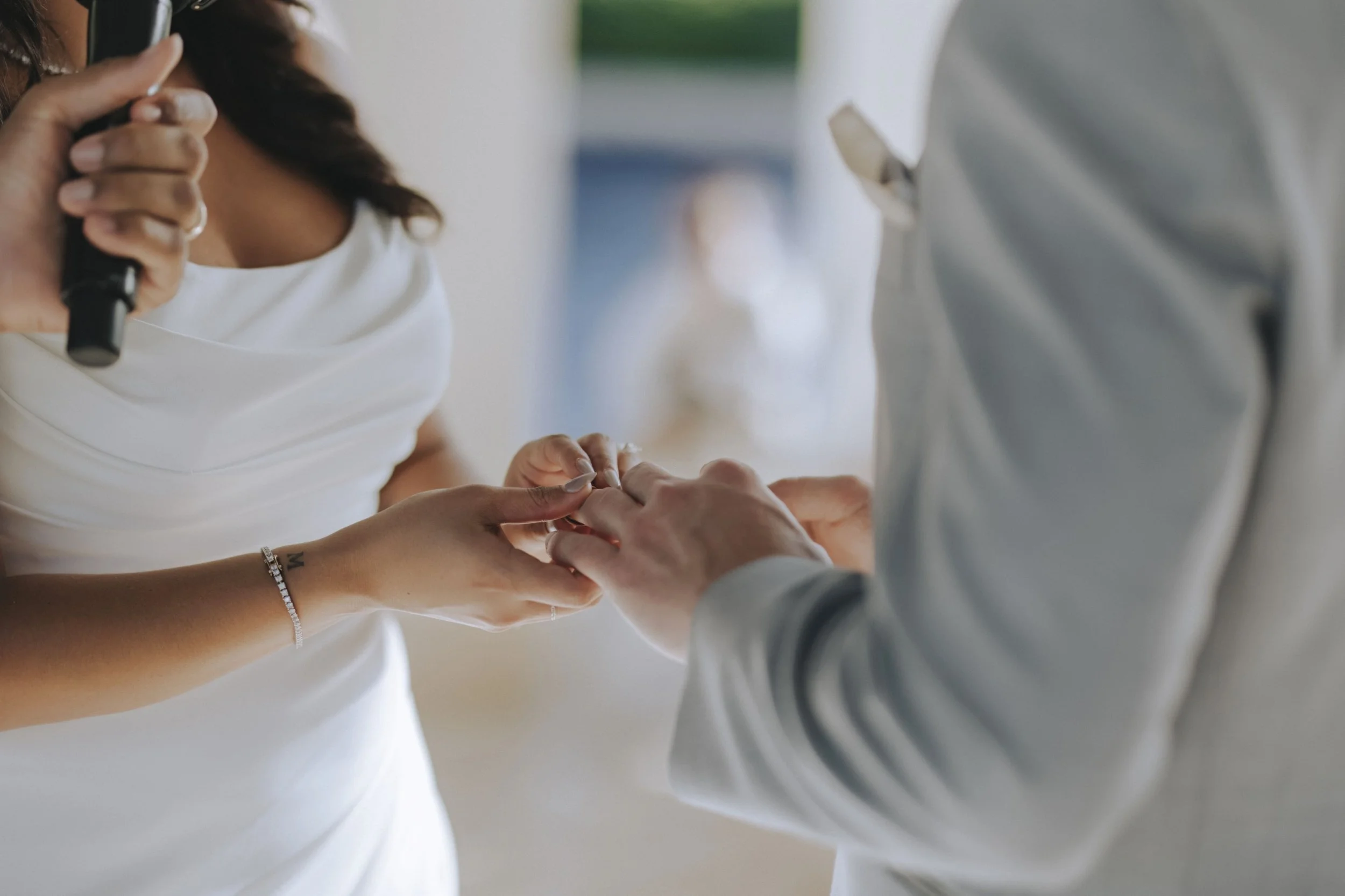 Close-up of bride and groom exchanging rings during their ceremony at Dreams Onyx