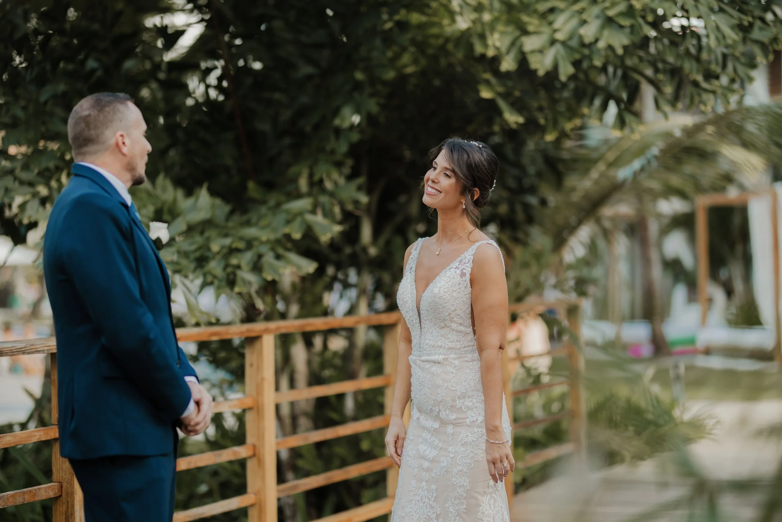 Bride smiling at her groom during their first look on a wooden boardwalk at Dreams Flora