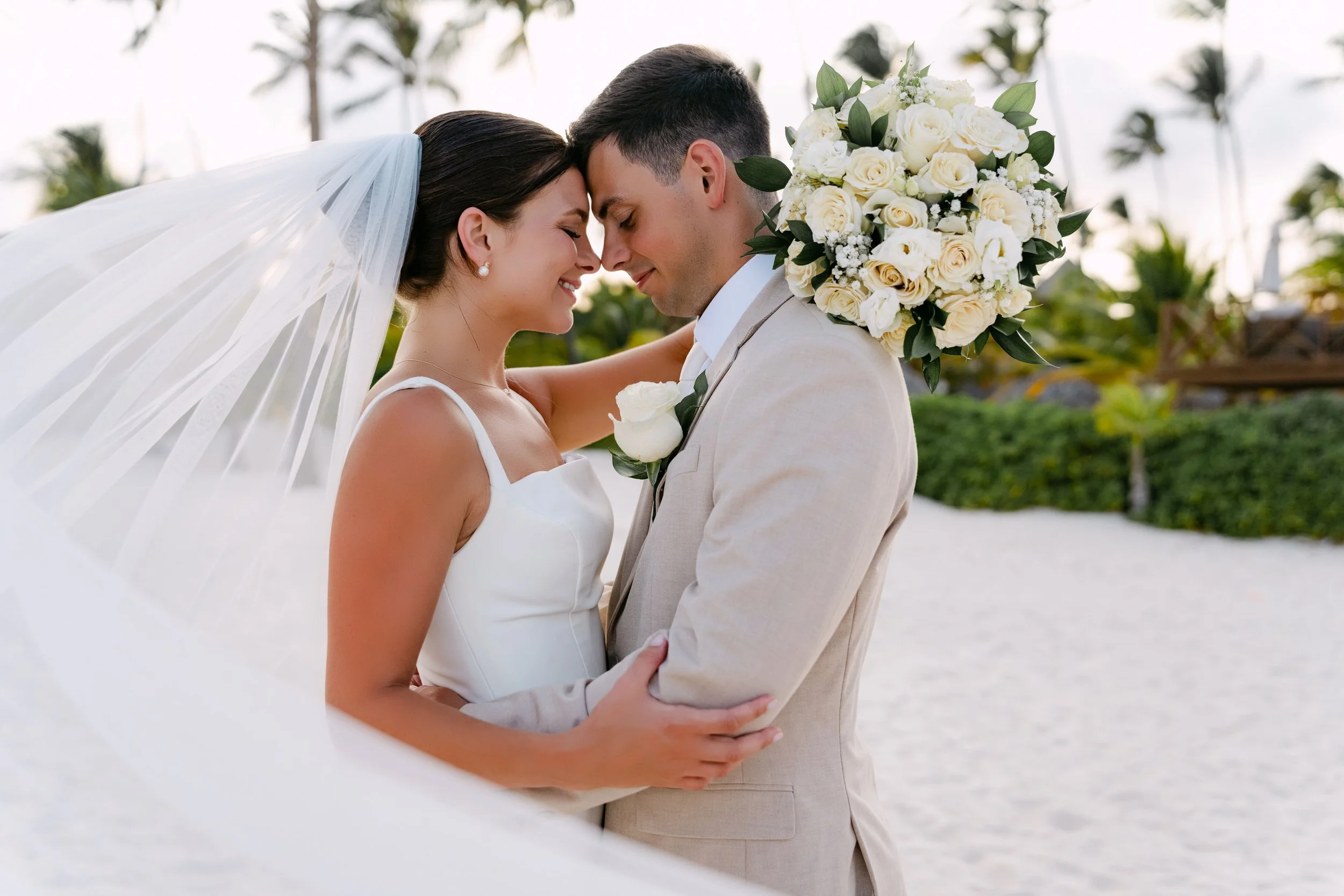 Bride and groom forehead to forehead on the beach, real wedding at Dreams Royal Beach Punta Cana.