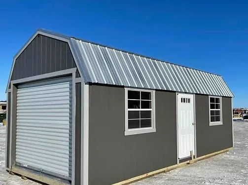 Gray storage shed with metal roof and roll-up garage door