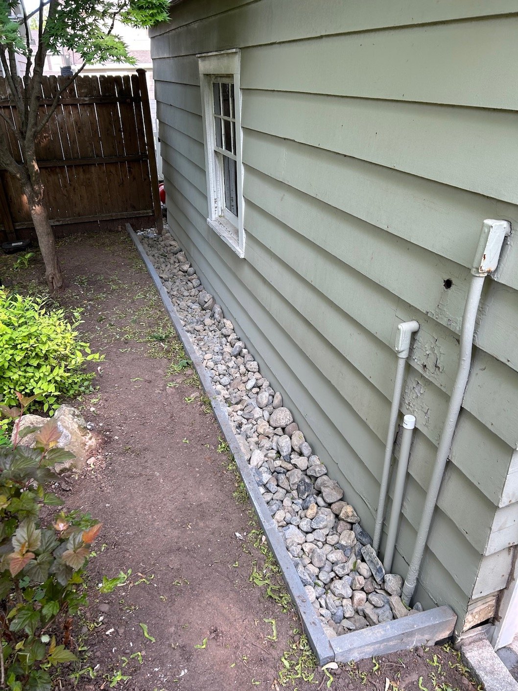 Side yard irrigation and drainage solution for home using natural stone rocks.jpg