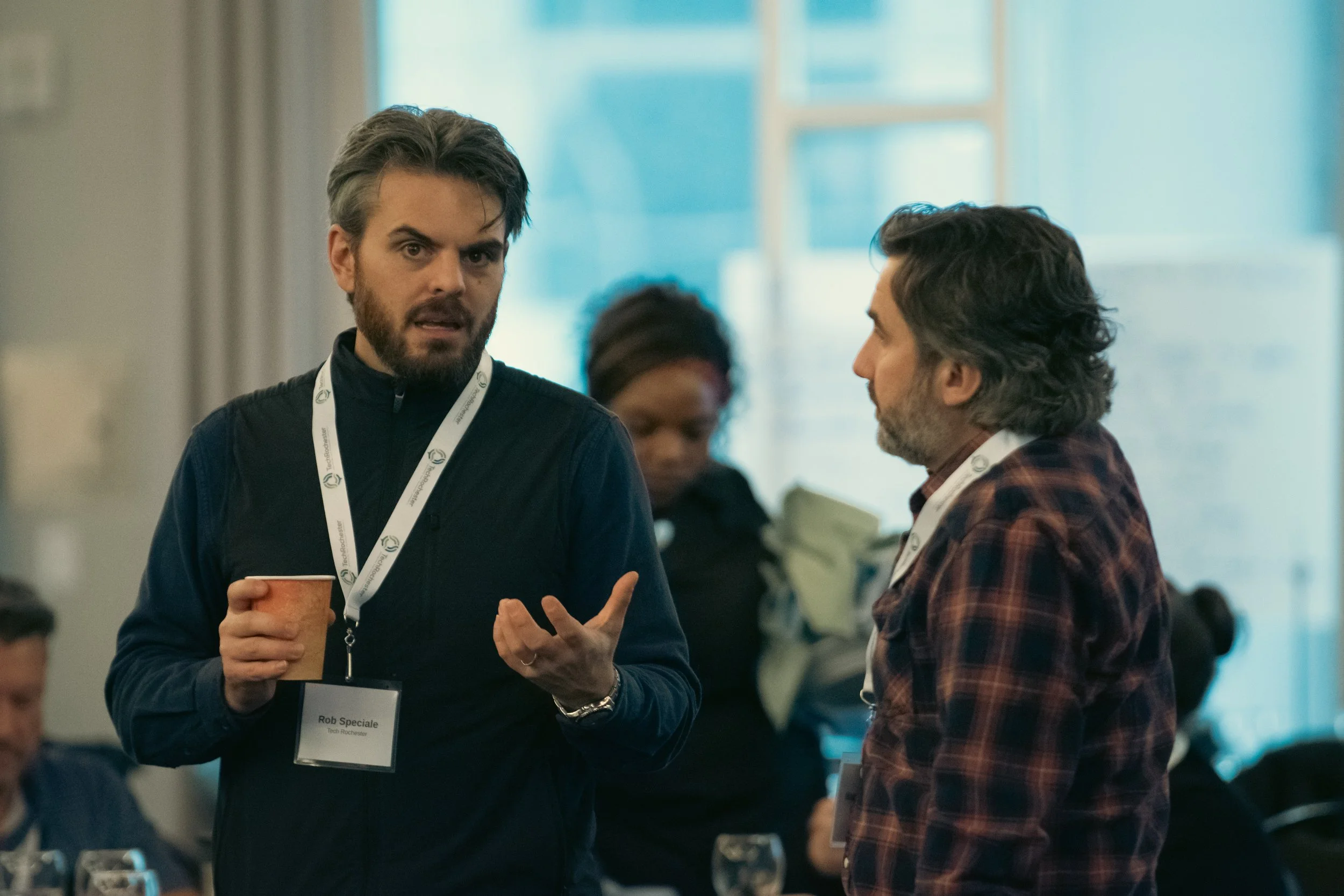Two men standing and speaking at a conference.