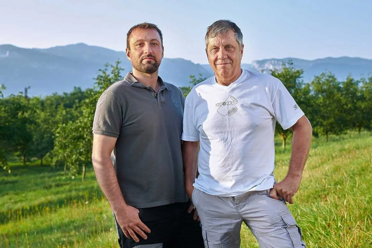 Loic et Philippe, devant un verger de noyer et le vercors en arrière plan, producteur de noix de père en fils