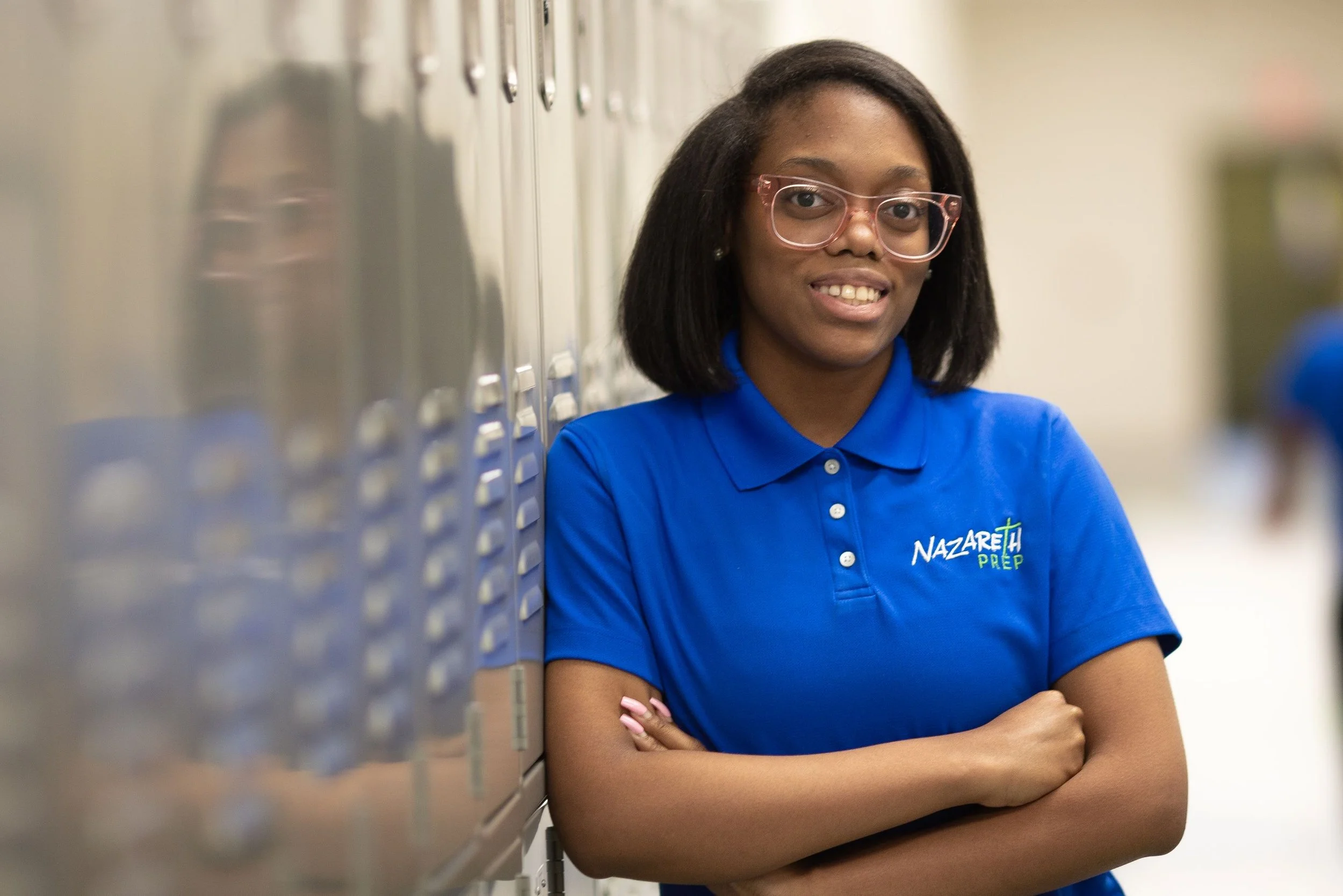 An image of a female student leaning against a row of lockers