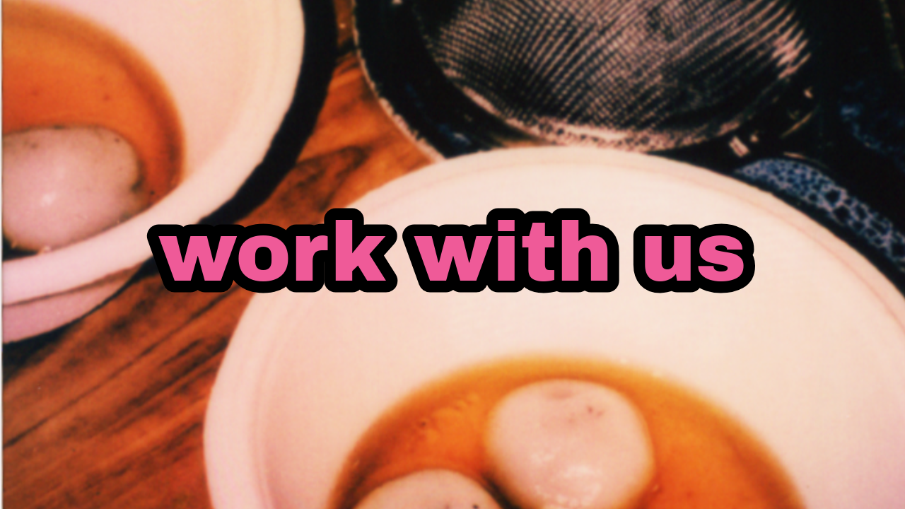 Close-up of two cups of coffee on a wooden table with the words "work with us" overlaid.