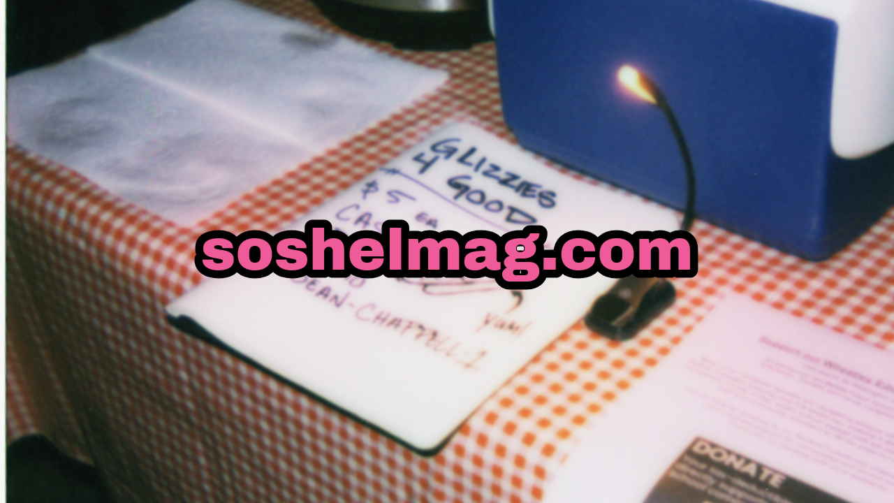 A table with a red and white checkered tablecloth displaying a tissue, a handwritten sign, a blue tissue box, a small light, and some pink and white papers.