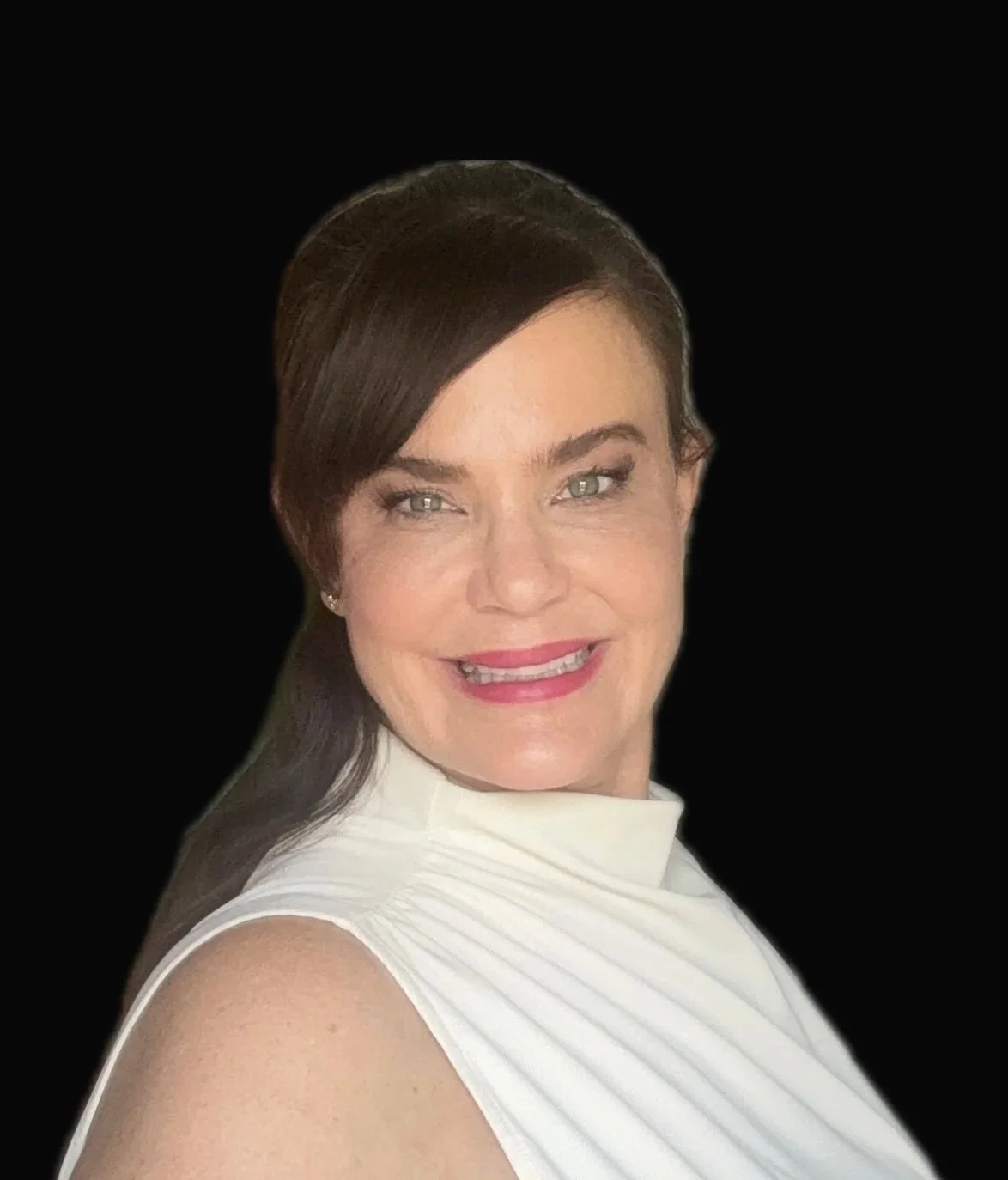 A woman with long brown hair, wearing a white sleeveless top, smiling, against a black background.