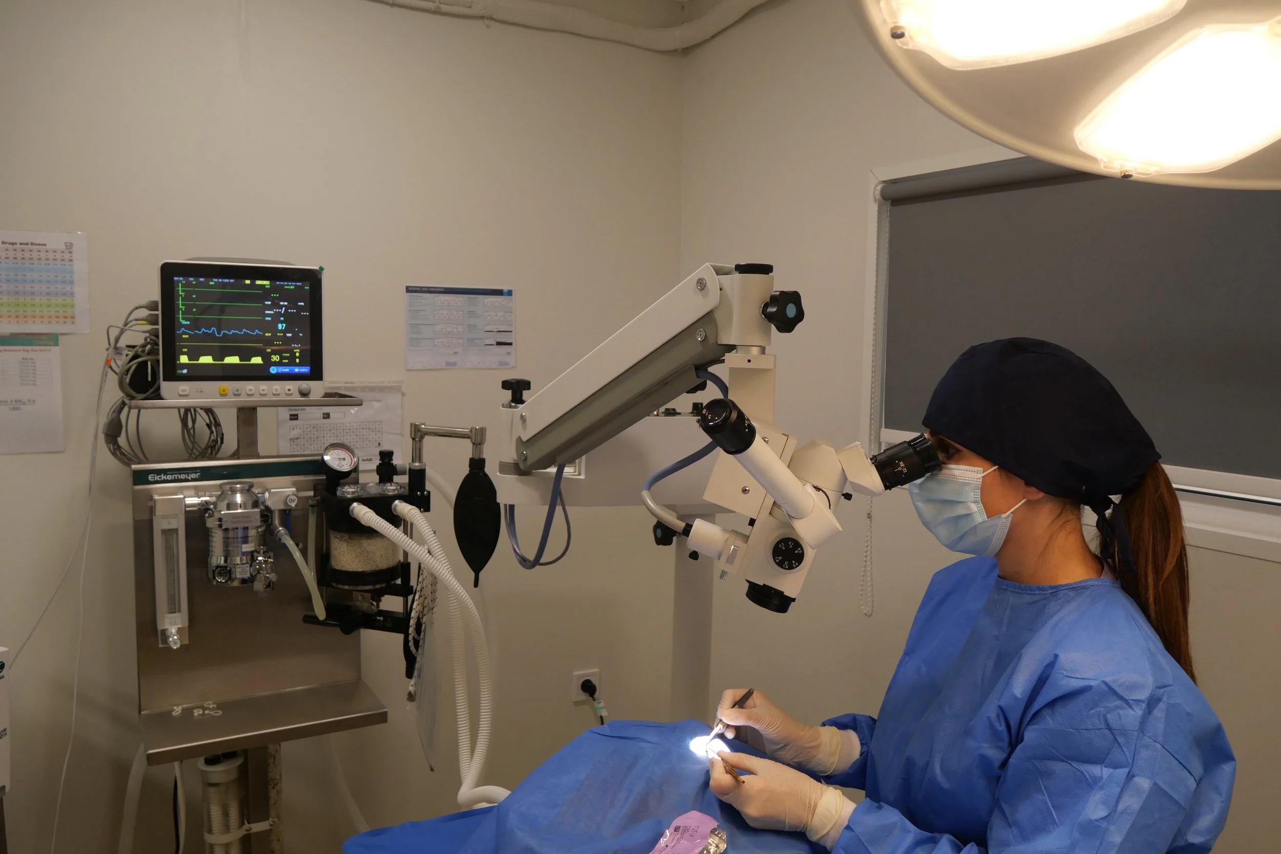 A surgeon is performing eye surgery using an operating microscope