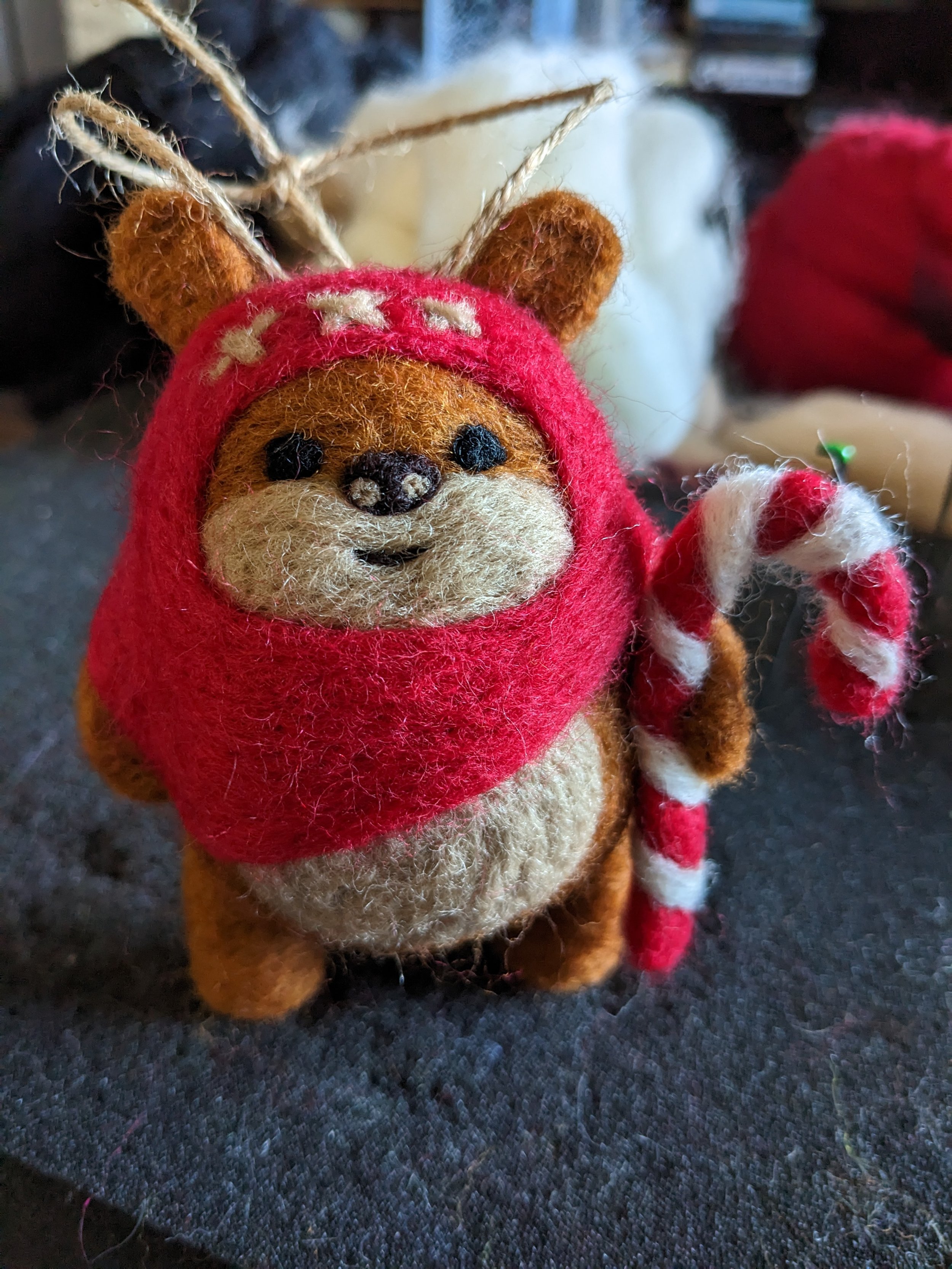 needle felted ewok holding a candy-cane