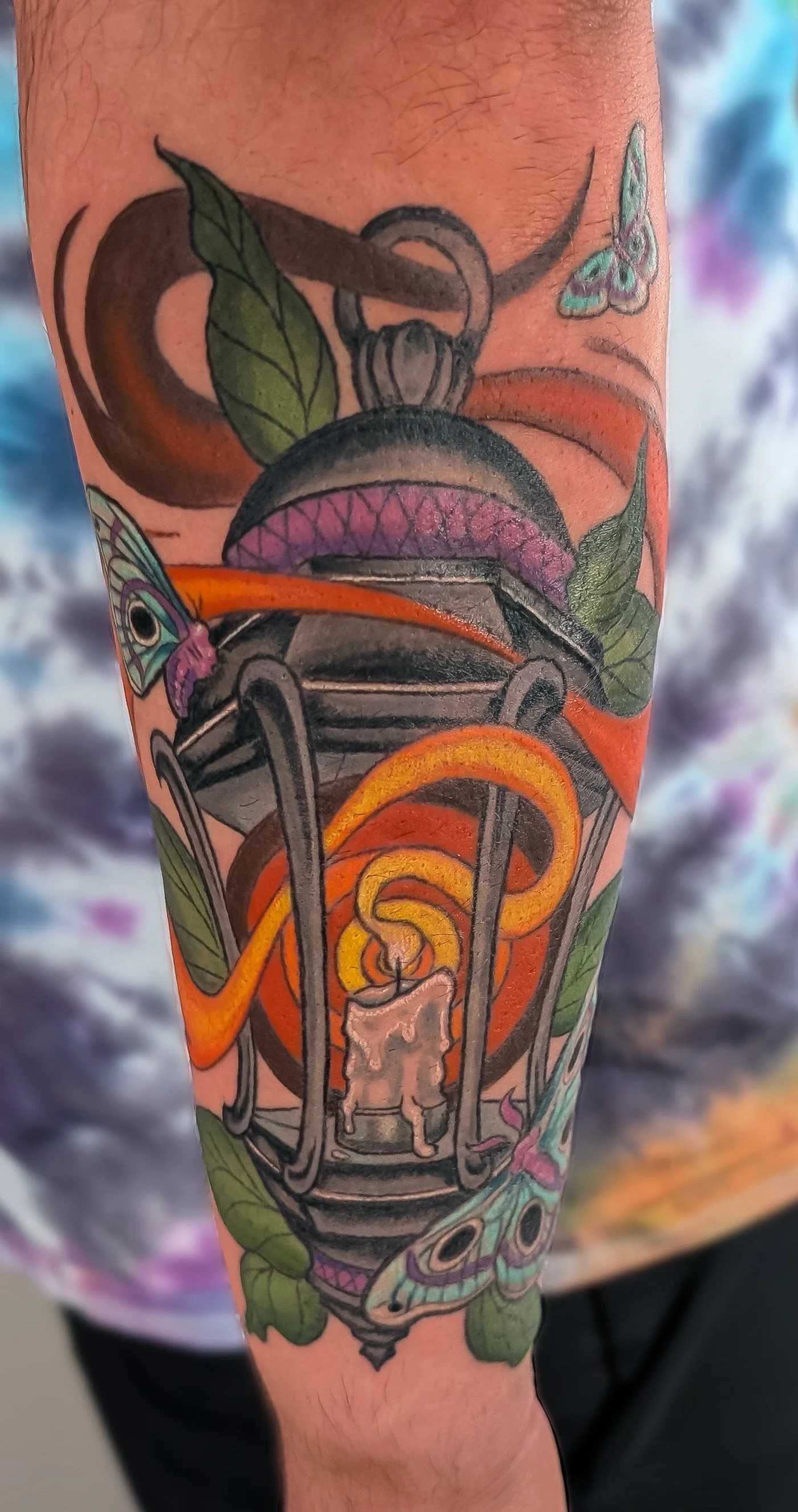 A rich and saturated neotraditional lantern tattoo with moths and leaves.  The tattoo fits the outer forearm perfectly and the flow of the design complements the client's musculature.  Made by Caitie Brianna at Bone and Lily Tattoo in Knoxville Tenne