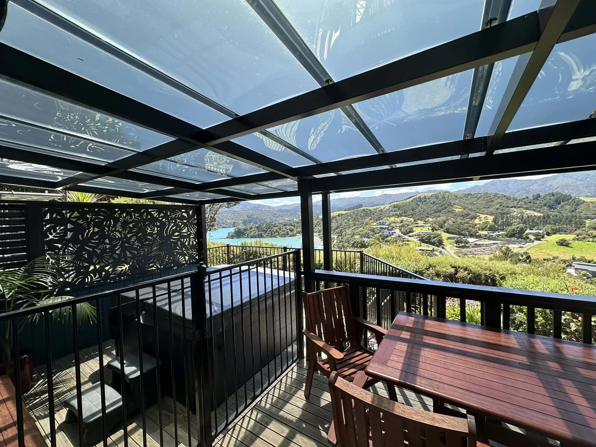 Spa Apartment view featuring the private spa and beautiful outlook over the hills and bay. Offering a peaceful spot to relax and enjoy Coromandel’s stunning scenery.