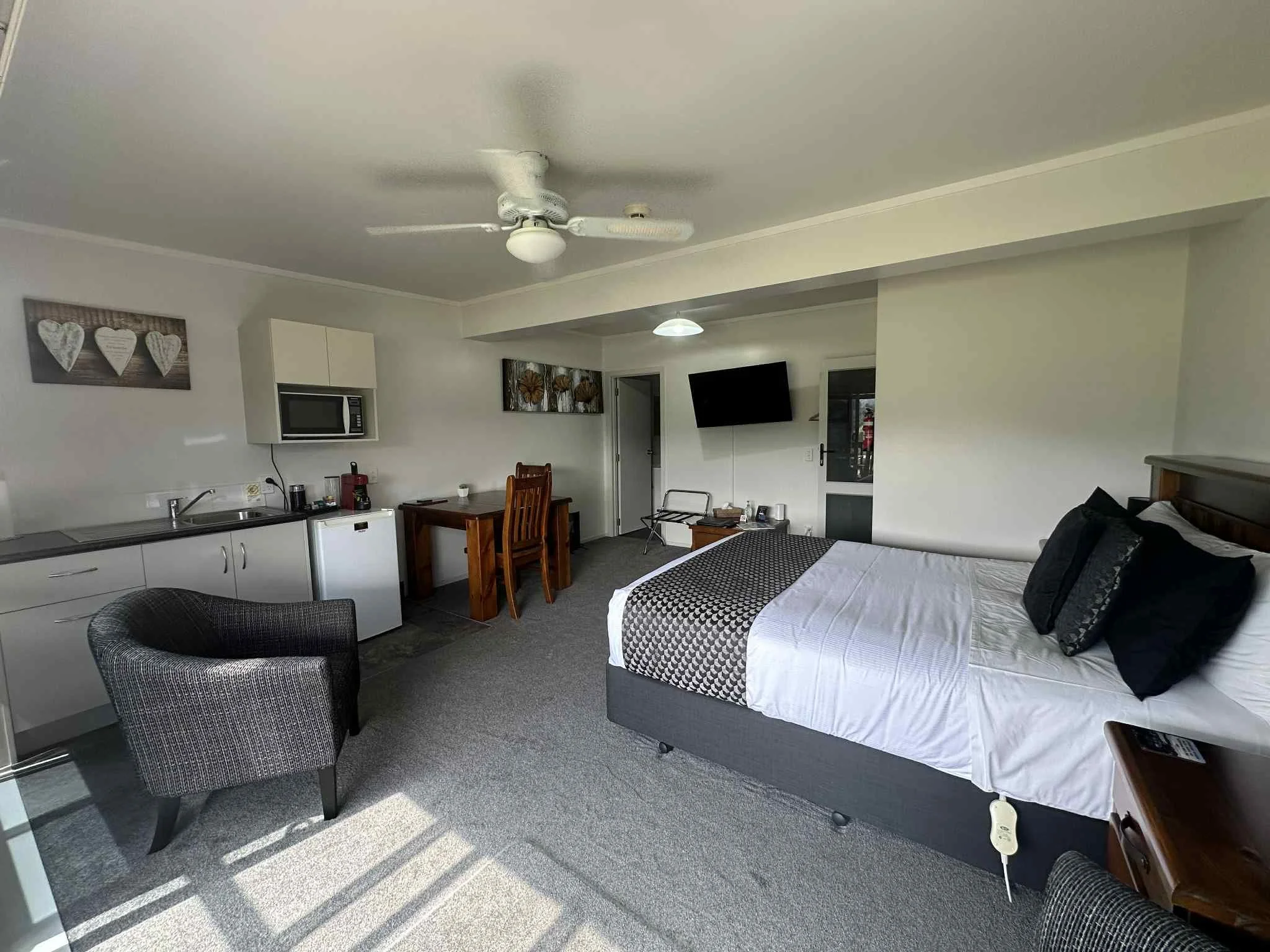 “Deluxe Studio — spacious coastal accommodation in Coromandel with queen bed, kitchenette, dining area, and modern comfort.”